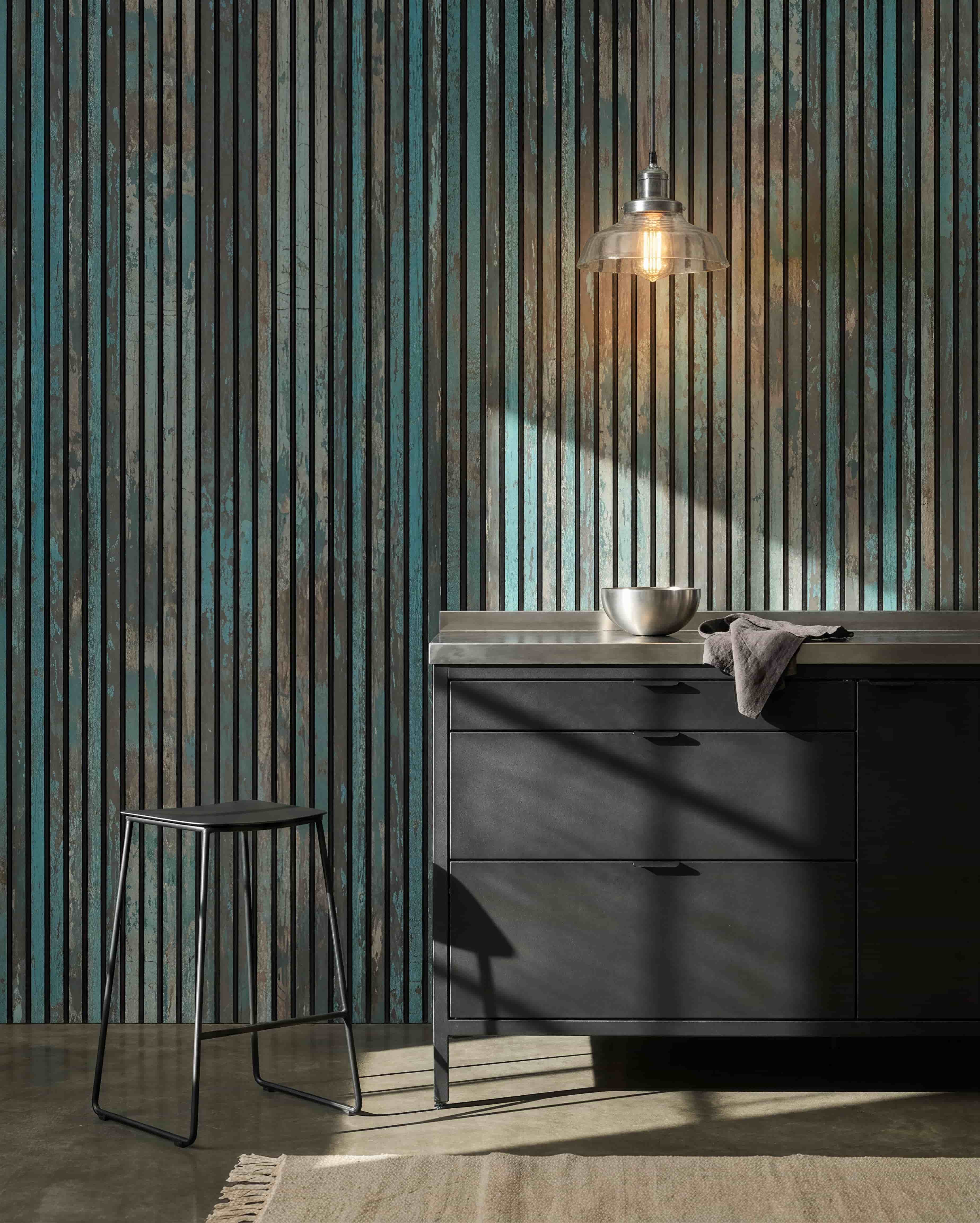 Moderne keuken met black krukken, black kasten, een schaal onder een hanglamp en een WoodUpp Akupanel Oxide Blue Akoestisch paneel aan de muur voor meer akoestisch comfort.