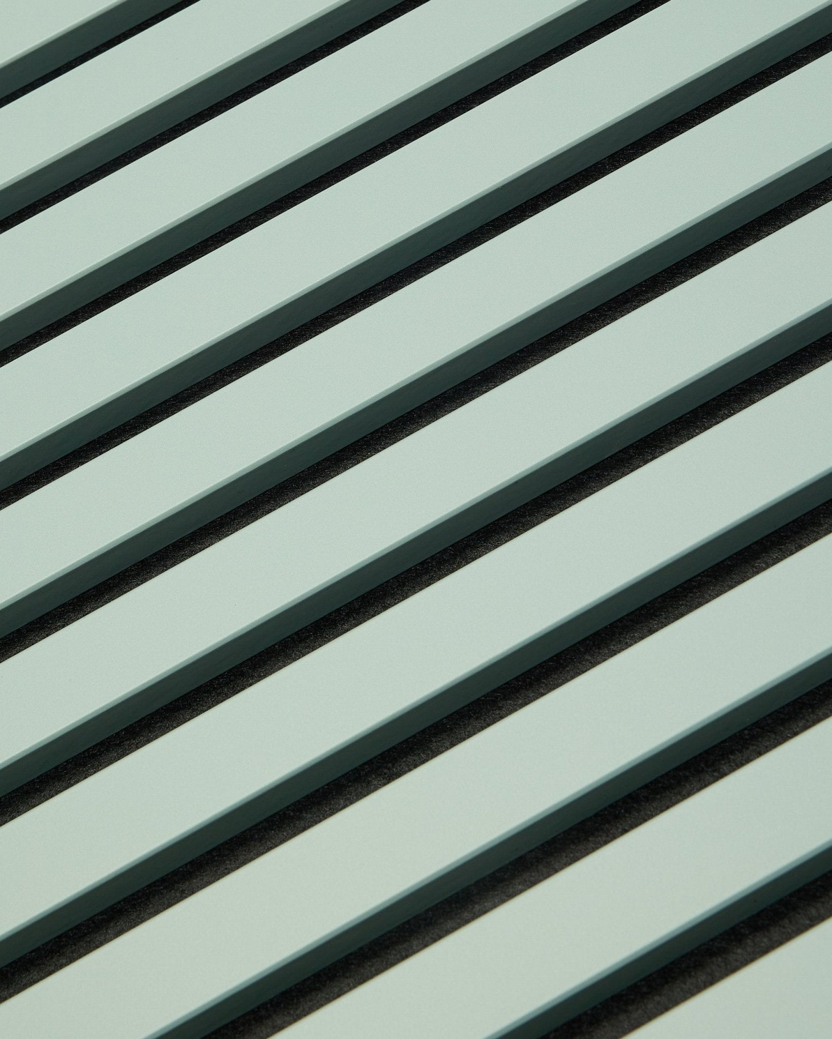 Hue | Akupanel / Cloud van WoodUpp toont lichtgroene akoestische houten panelen met vertical latten en donkere tussenruimtes, die een geometrisch patroon vormen voor geluidsabsorptie.