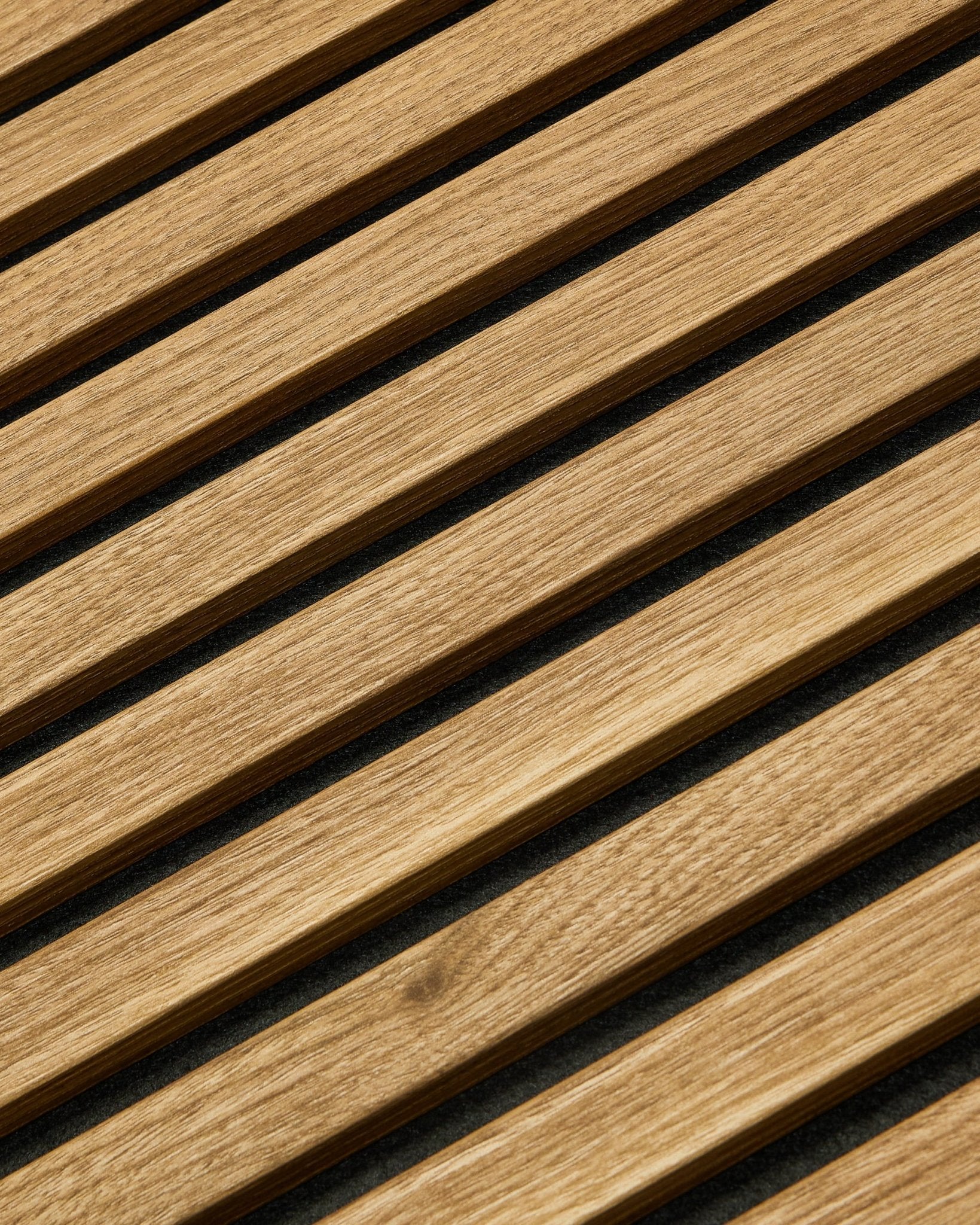 Essential Akupanel Akoestisch paneel in Engels eiken van WoodUpp, 240 x 60 cm, met gelijkmatig verdeelde diagonale latten op een donkere achtergrond.