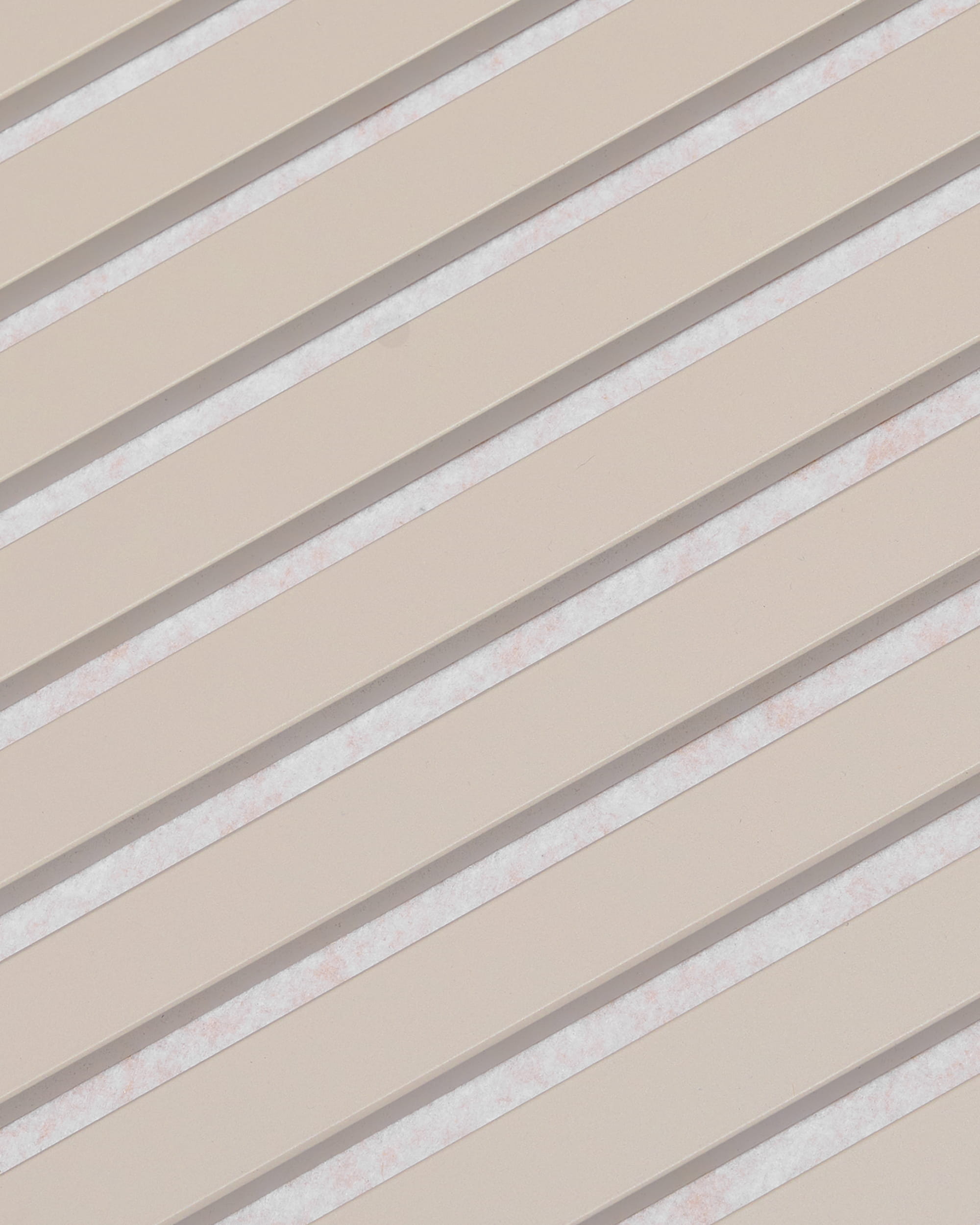 Diagonale beige lamellen met witte tussenruimtes vormen een gestreept patroon op het WoodUpp Akupanel akoestisch paneel, met een afwerking van Soft Linen Light Beige-vilt, 240 x 60 cm.