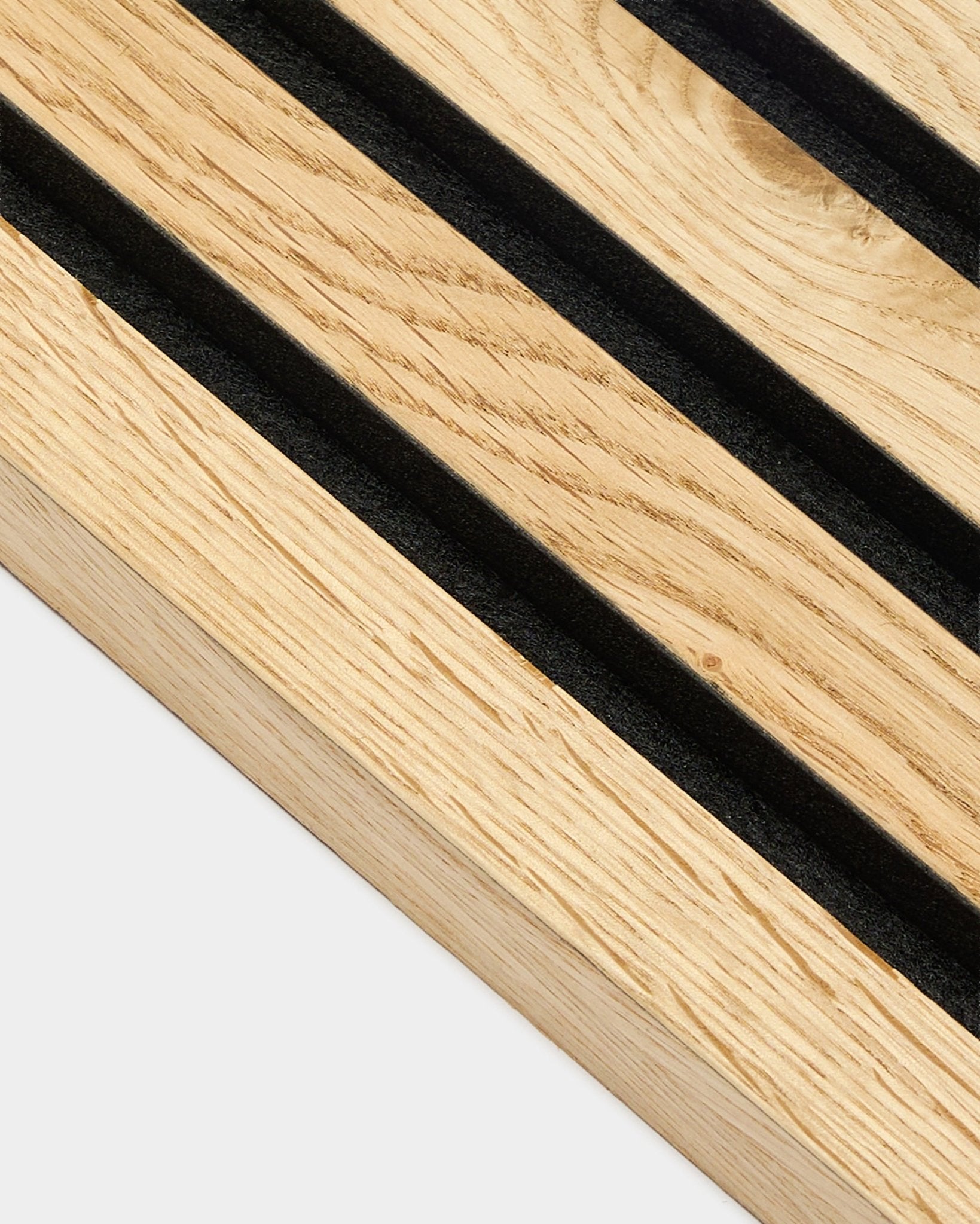 Close-up van de WoodUpp Akupanel eindlamel in rustiek natural oak, 2,2 cm dik, met diagonale black groeven en een zichtbare natural wood nerfstructuur.