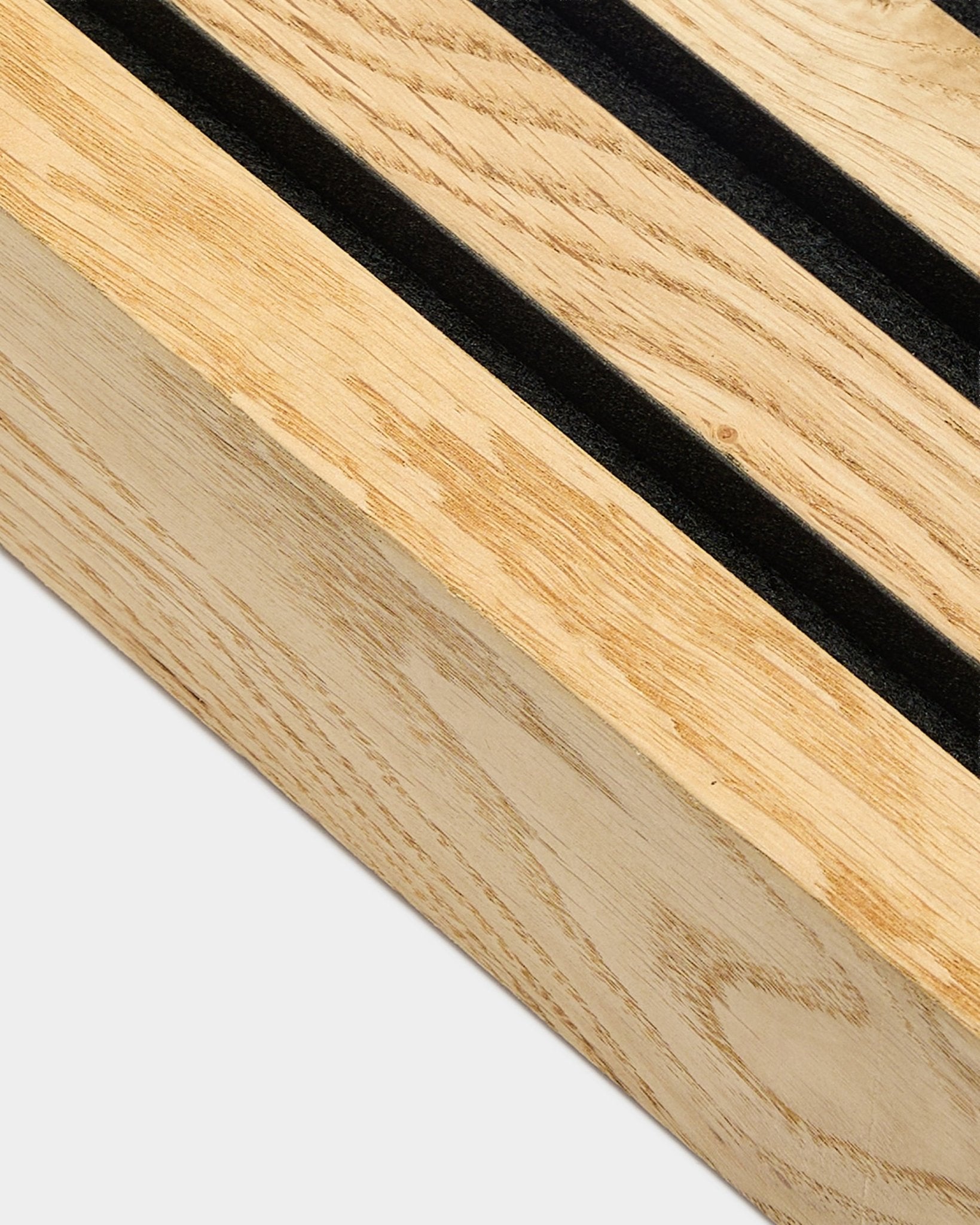 Close-up van een WoodUpp Akupanel eindlamel in Rustic Natural Oak, 6,7 cm, met parallelle black sleuven en een MDF-frame voor akoestische wandinstallatie.