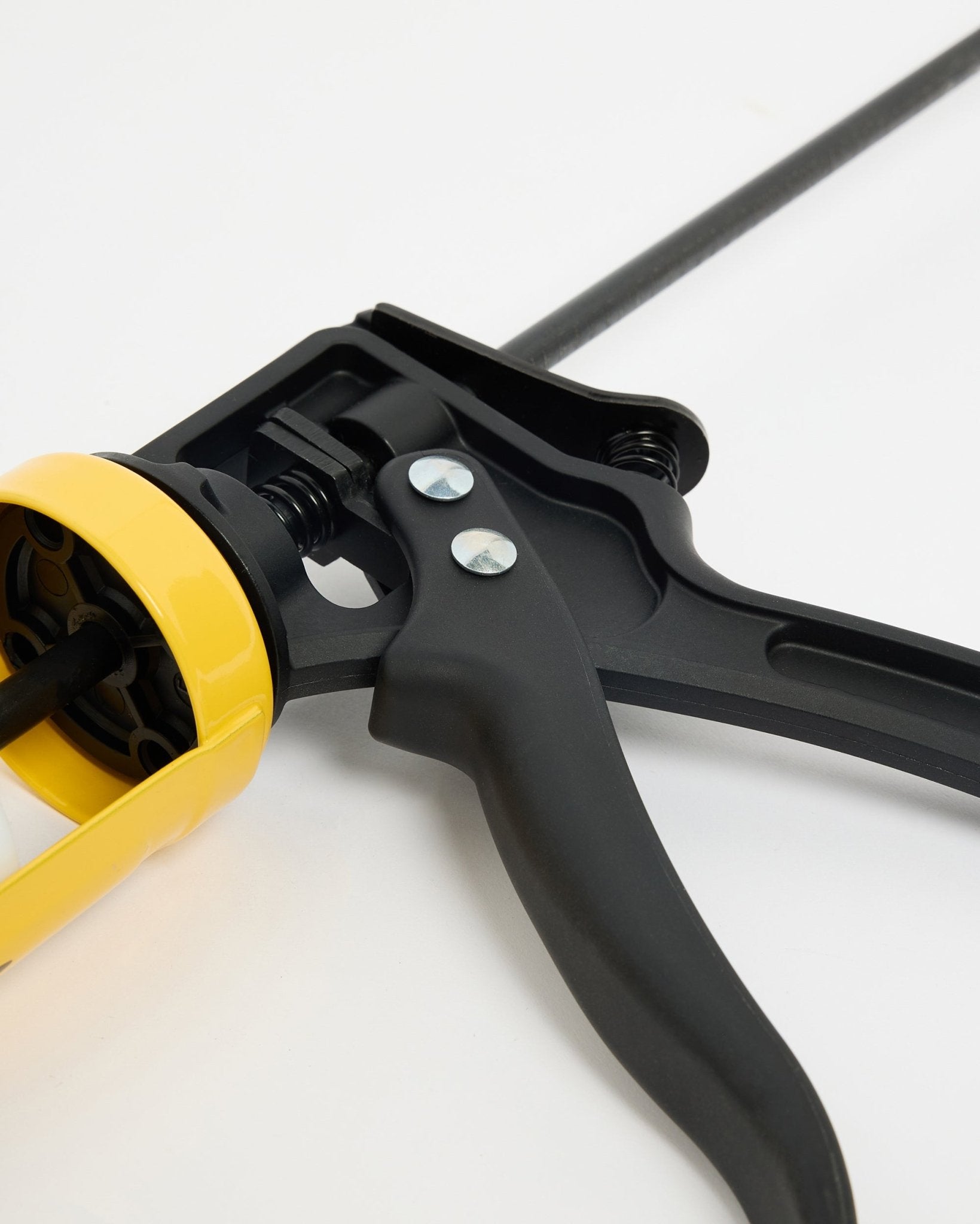 Close-up van de WoodUpp black en het gele voegkitpistool (290 ml), een CREATE-accessoire voor de installatie van Akupanel Akoestisch paneel, afgebeeld op een wit oppervlak.