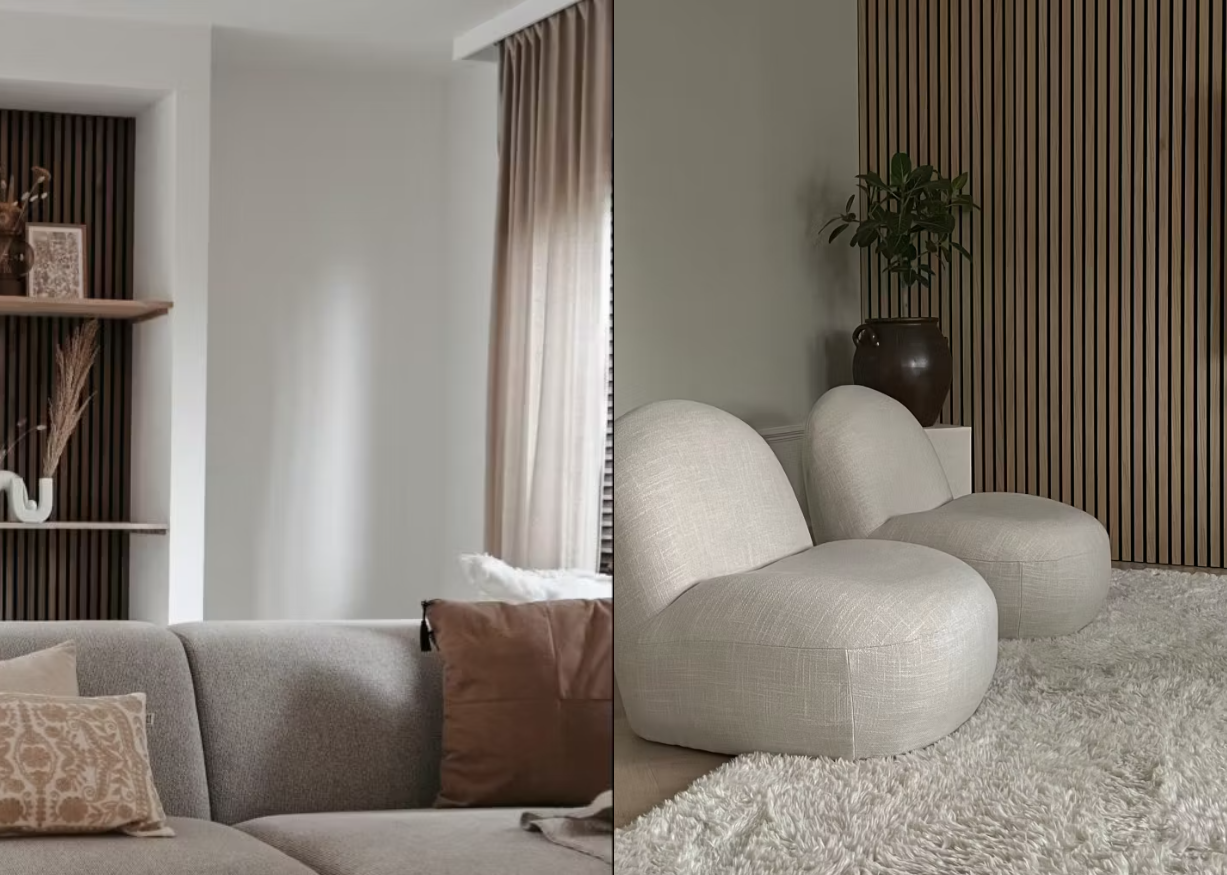 Moderne woonkamer met neutraal getinte banken, een vloerkleed met structuur en een accentmuur van akoestische panelen met houten latten, verlicht door zacht natuurlijk licht van grote ramen.