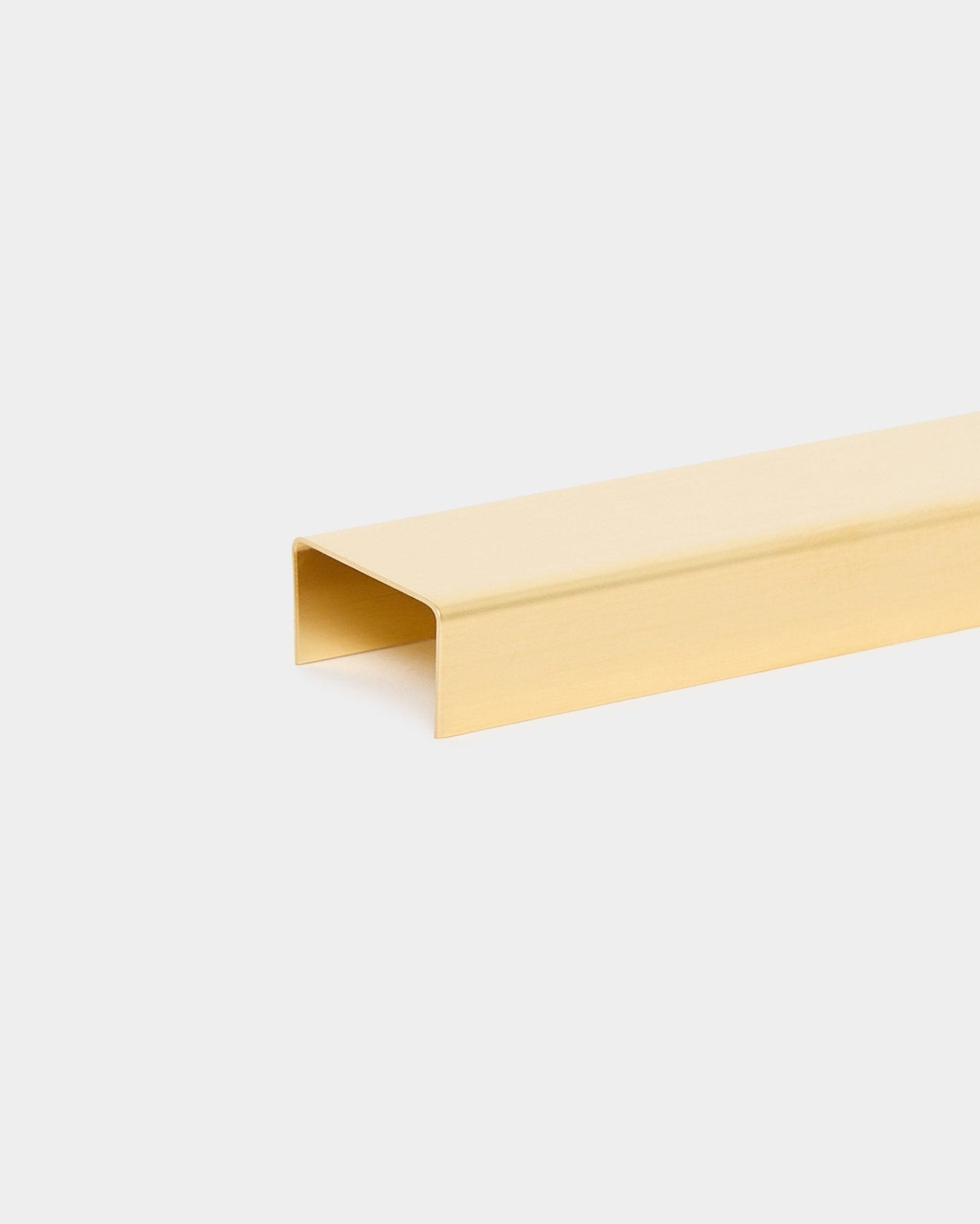 De Liva Cover in brass, 20 cm, van WoodUpp is een goudkleurig U-vormig metalen profiel, ontworpen als afwerkkap voor Akupanel akoestische houten panelen.