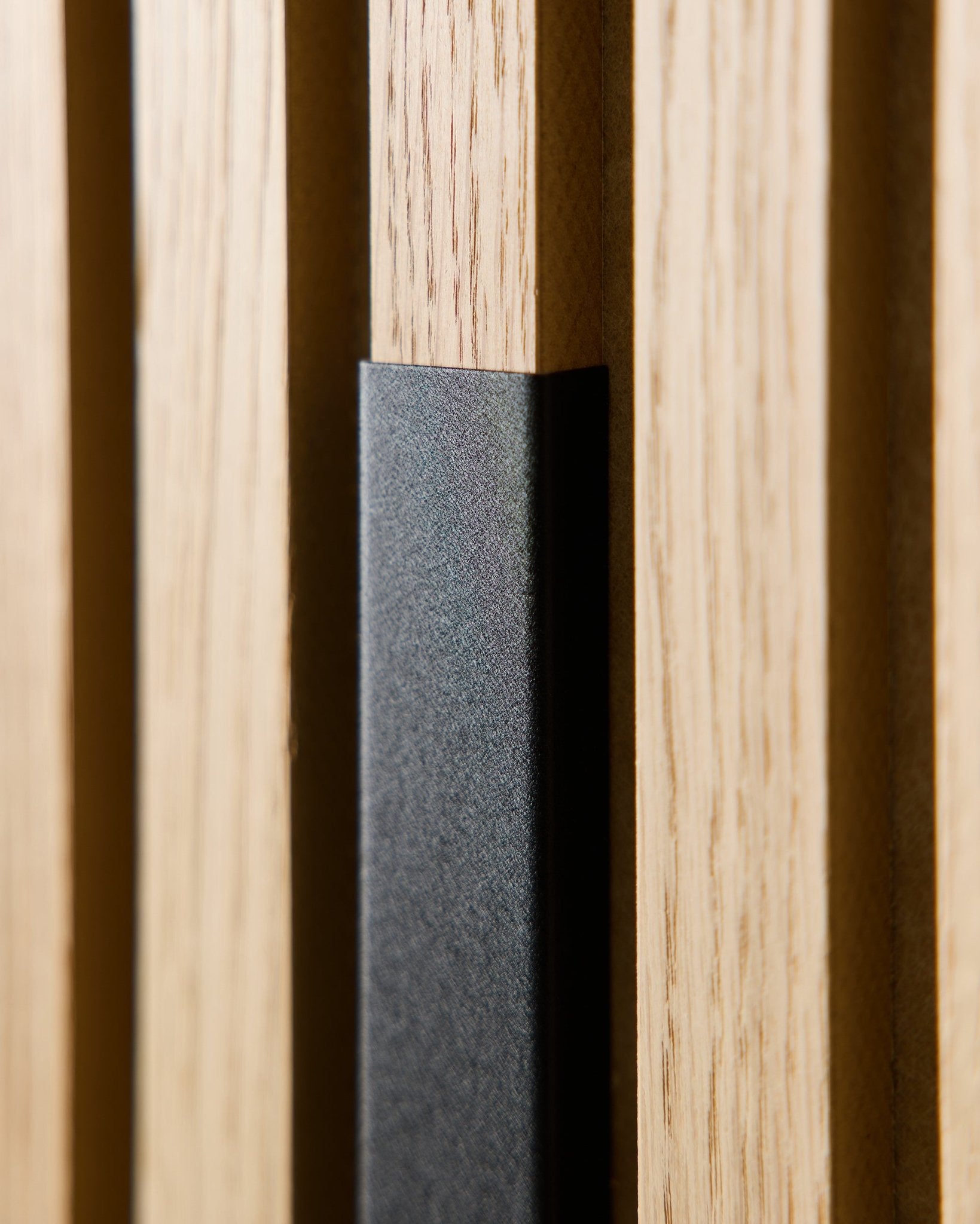 Close-up van WoodUpp Liva Akoestisch paneel met 60 cm black aluminium afwerking, met vertical houten latten en een black accent voor moderne, Scandinavische interieurs.