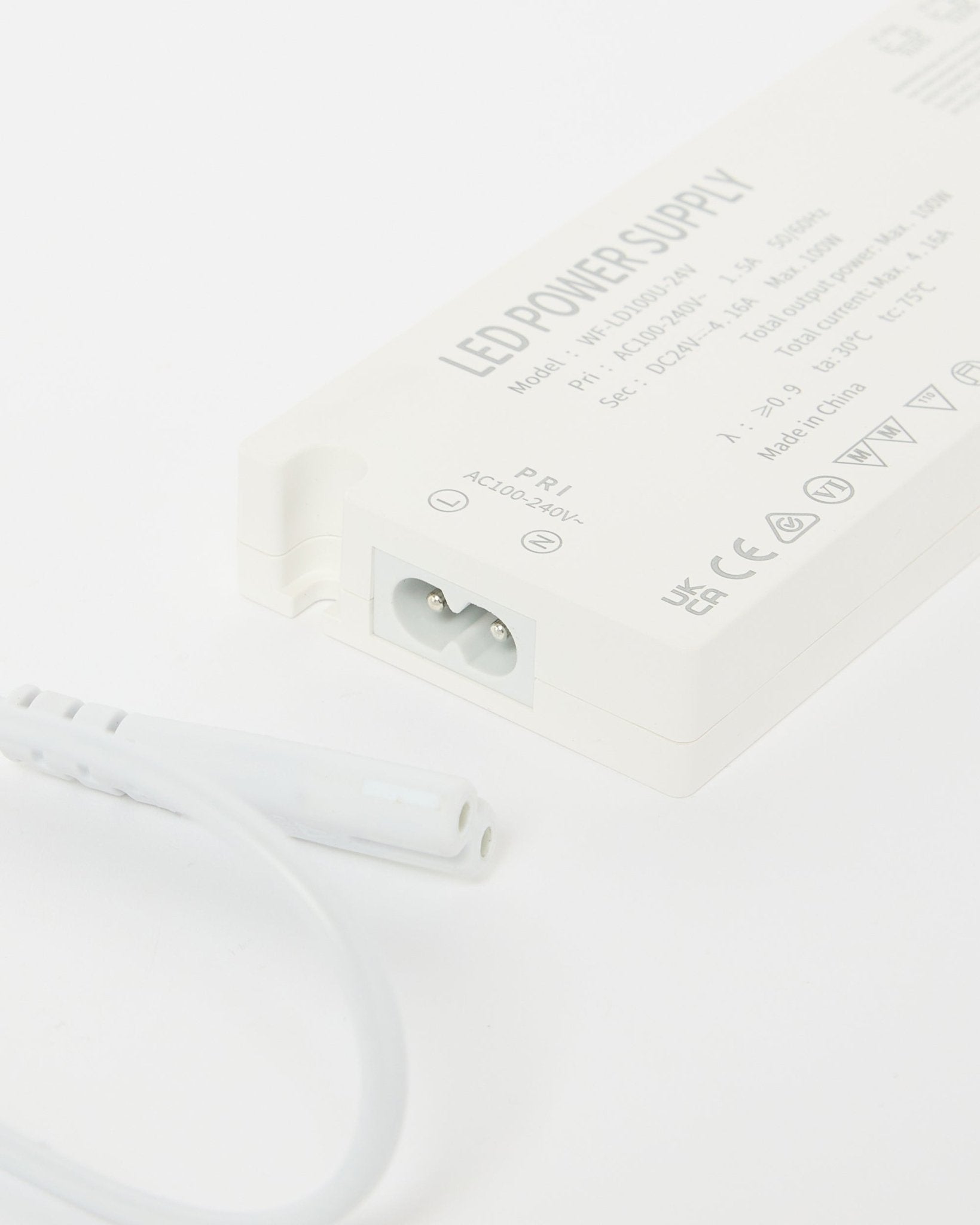 Close-up van een voeding voor beige WoodUpp Lumi ledstrips (240 cm), met technische details en een kabel ernaast, ontworpen voor Noordse Akoestisch paneel installaties.