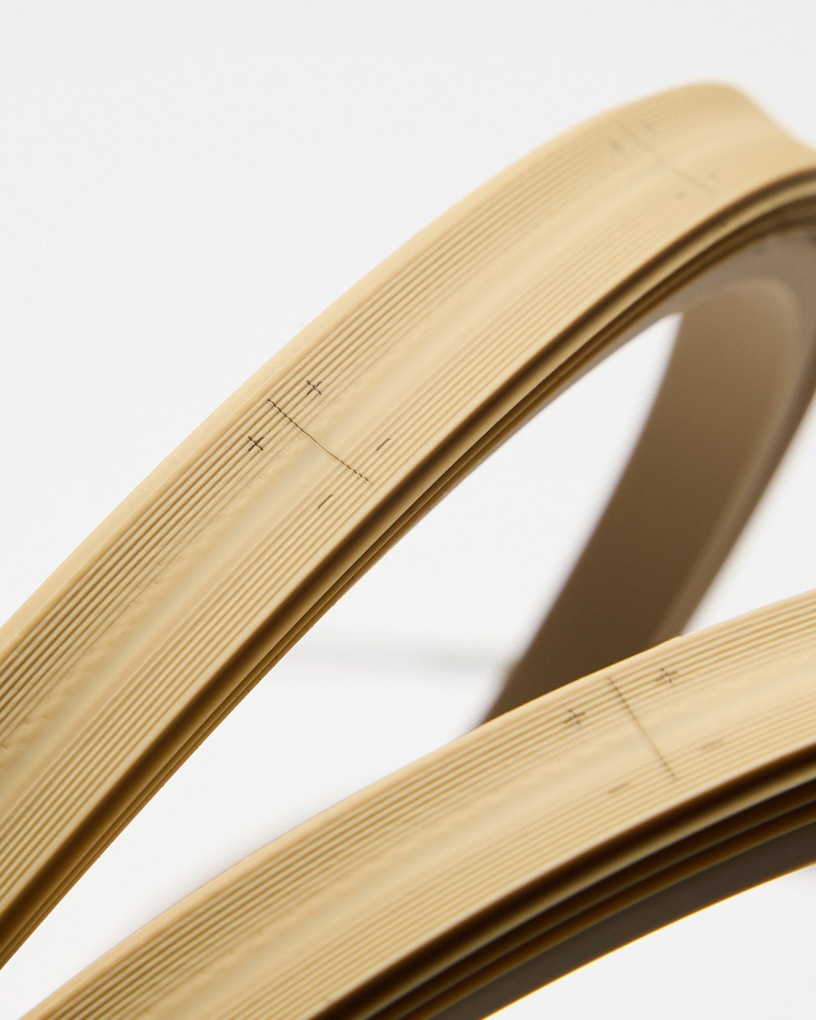 Close-up van twee beige WoodUpp Lumi ledstrips, elk 240 cm lang, met fijne lijnen en markeringen, weergegeven tegen een effen witte achtergrond.