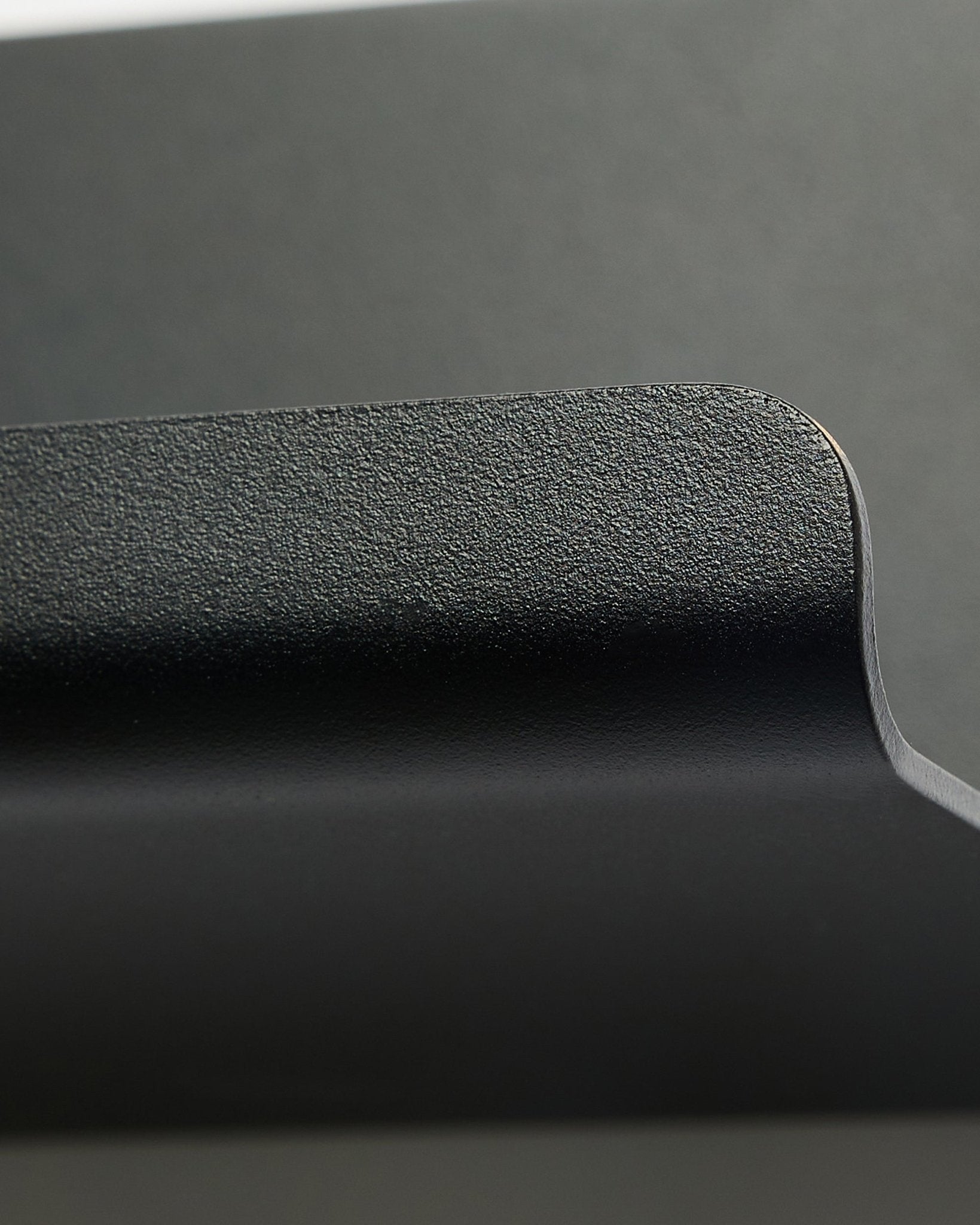 Norr | Wide Shelf van WoodUpp in black, 75,9 cm, met een rand met textuur en een vloeiende curve, in een minimalistisch Nordisch design tegen een gladde grijze achtergrond.