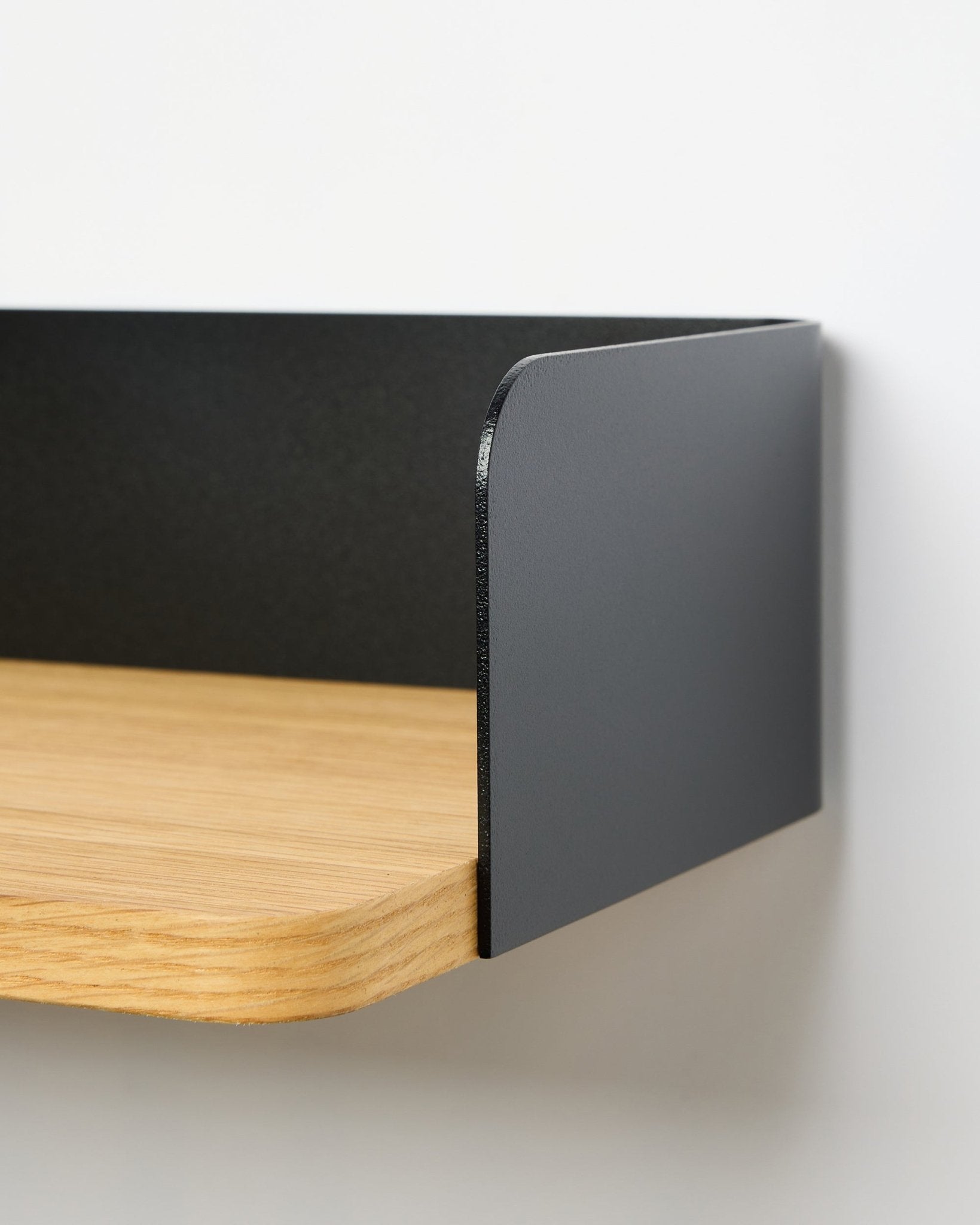 Close-up van de WoodUpp Linn boekenplank in Natural Oak, 39,9 cm breed, met een black metalen zijpaneel; plank zonder boren tegen een witte achtergrond.