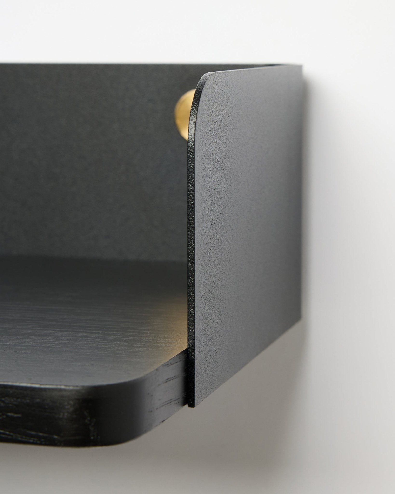 Close-up van de WoodUpp Linn Bookshelf in Black Oak, 39,9 cm breed met afgeronde randen en een matte afwerking, gemonteerd op een witte muur. Scandinavische minimalistische stijl.