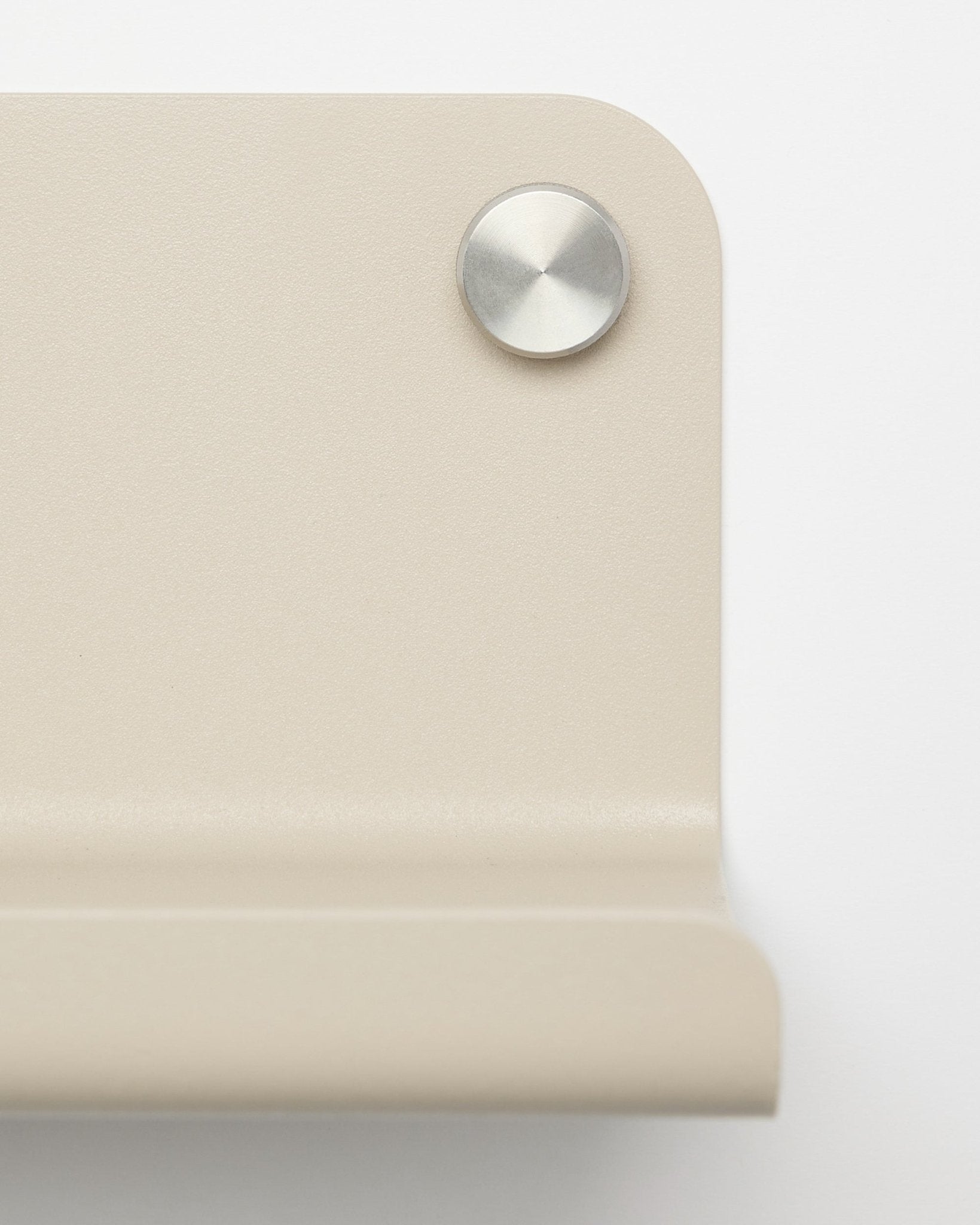 Close-up van een beige metalen hoekbeugel met een ronde zilverkleurige schroef, ontworpen voor de WoodUpp Norr Wide Shelf, 35,9 cm, afgebeeld tegen een witte achtergrond.