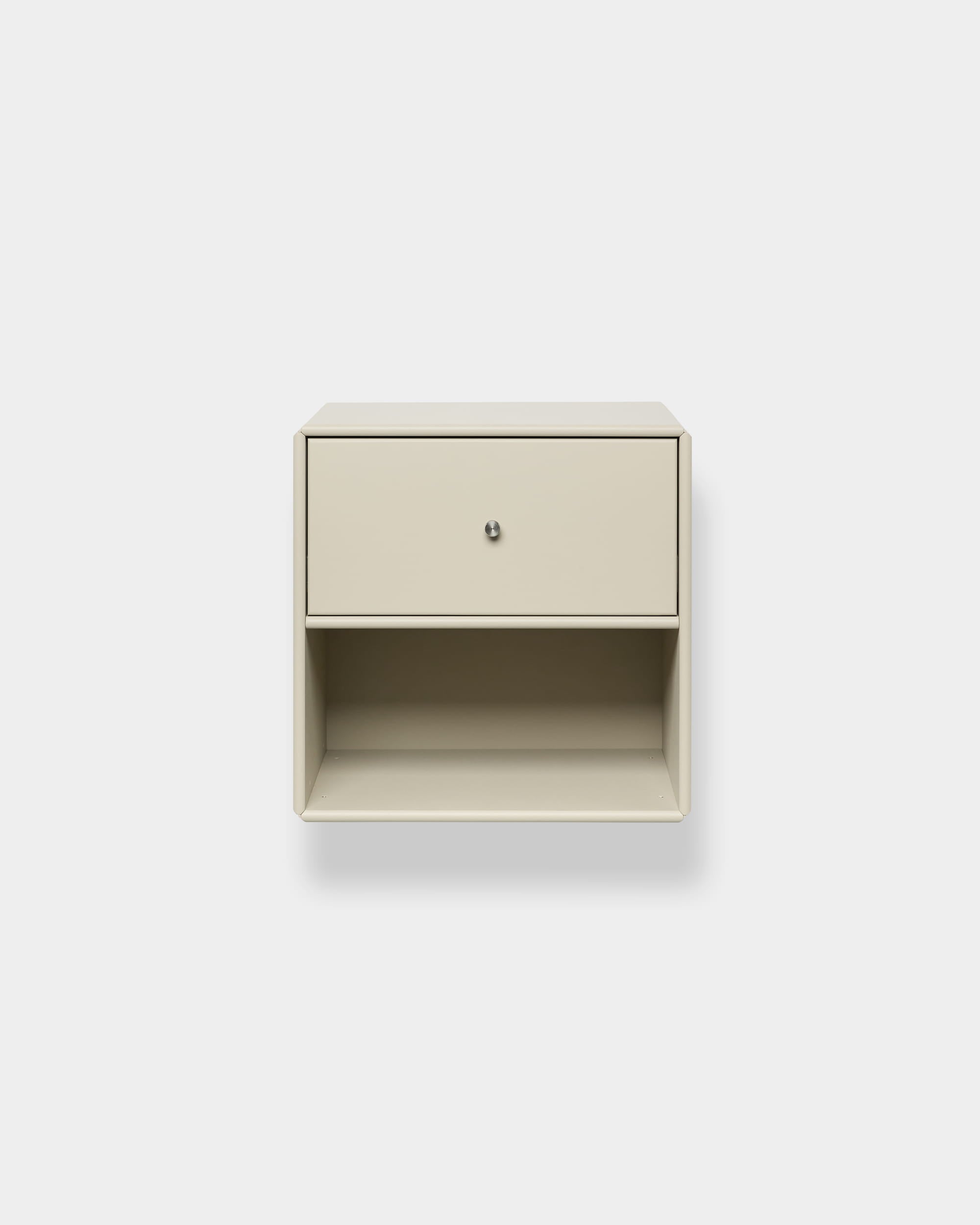 Beige Arka-boekenkast met lade van WoodUpp, aan de muur bevestigd, met een bovenste lade en een open plank, gesloten opbergruimte, afgebeeld tegen een effen witte achtergrond.