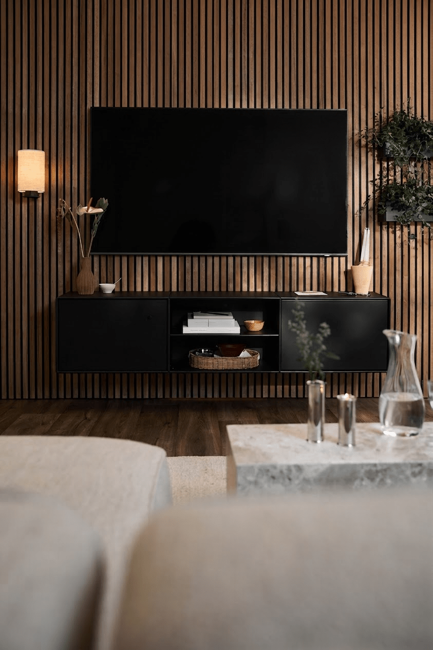 Moderne woonkamer met een WoodUpp Arka tv-meubel in het zwart, een Akupanel-lamellenwand, minimalistische accenten en een lichte bank met salontafel.