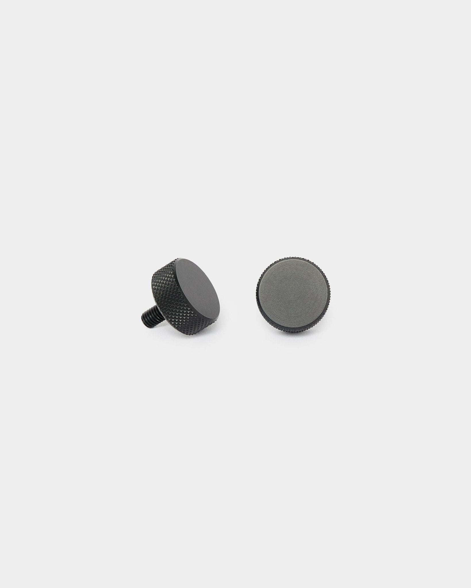 Twee black WoodUpp Finger-schroeven (2 stuks, M5x10mm, 20x8.8) rechtop en liggend op een effen witte achtergrond, voor installatie van Akupanel.