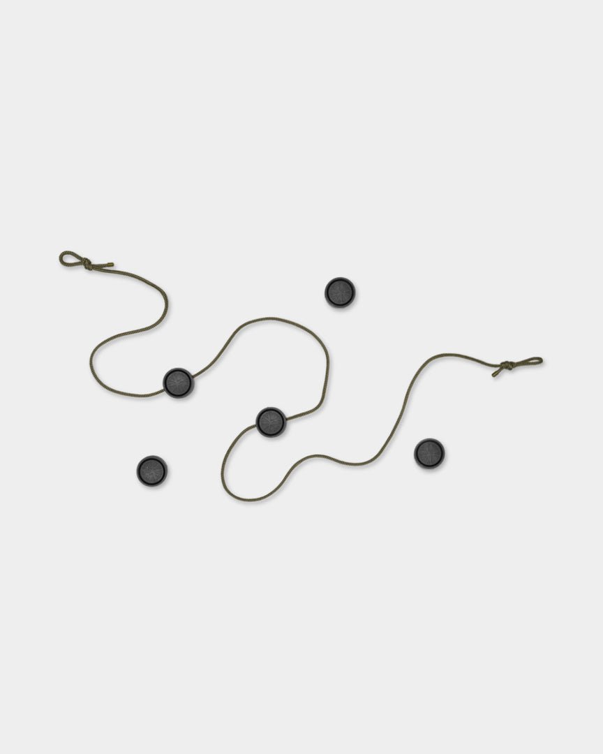 De Vindar | Gallery String van WoodUpp heeft een brown koord met magnetische clips en vier black cirkels, afgebeeld op een lichtgrijze achtergrond.