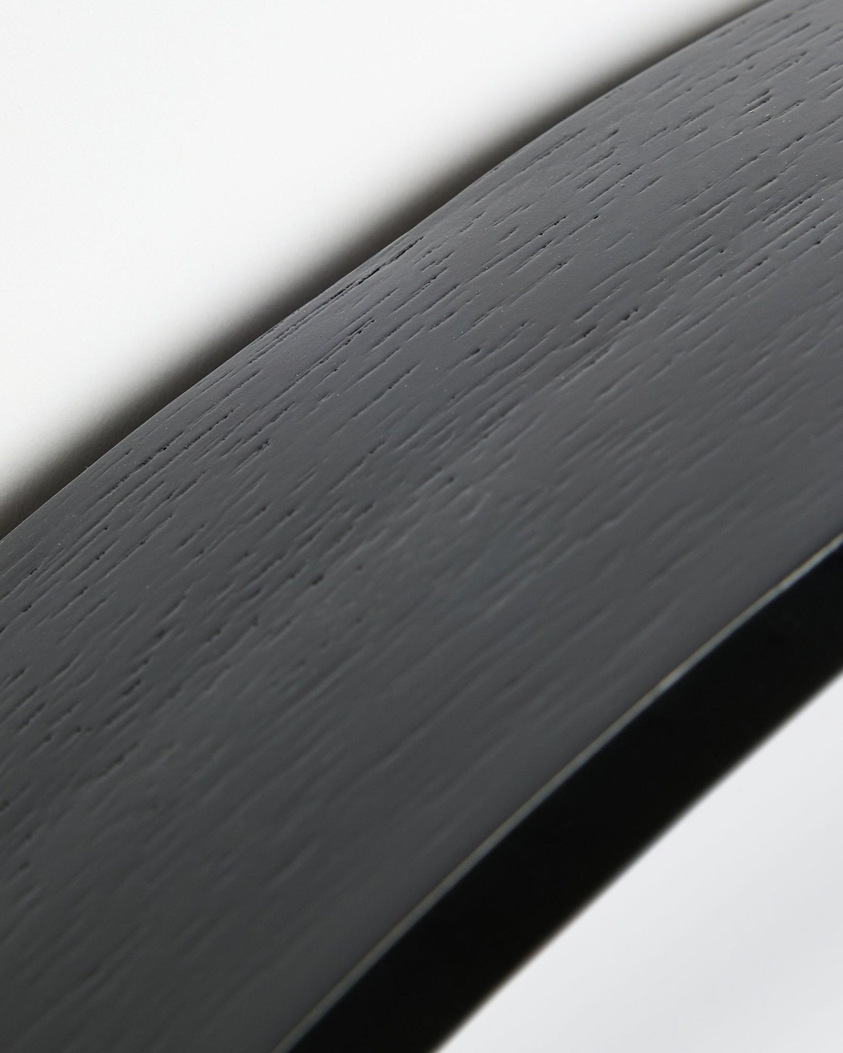 Close-up van de Linn | Mirror / Black Oak Akoestisch paneel van WoodUpp, met een gebogen black oak oppervlak en lijst, afgebeeld tegen een witte achtergrond.