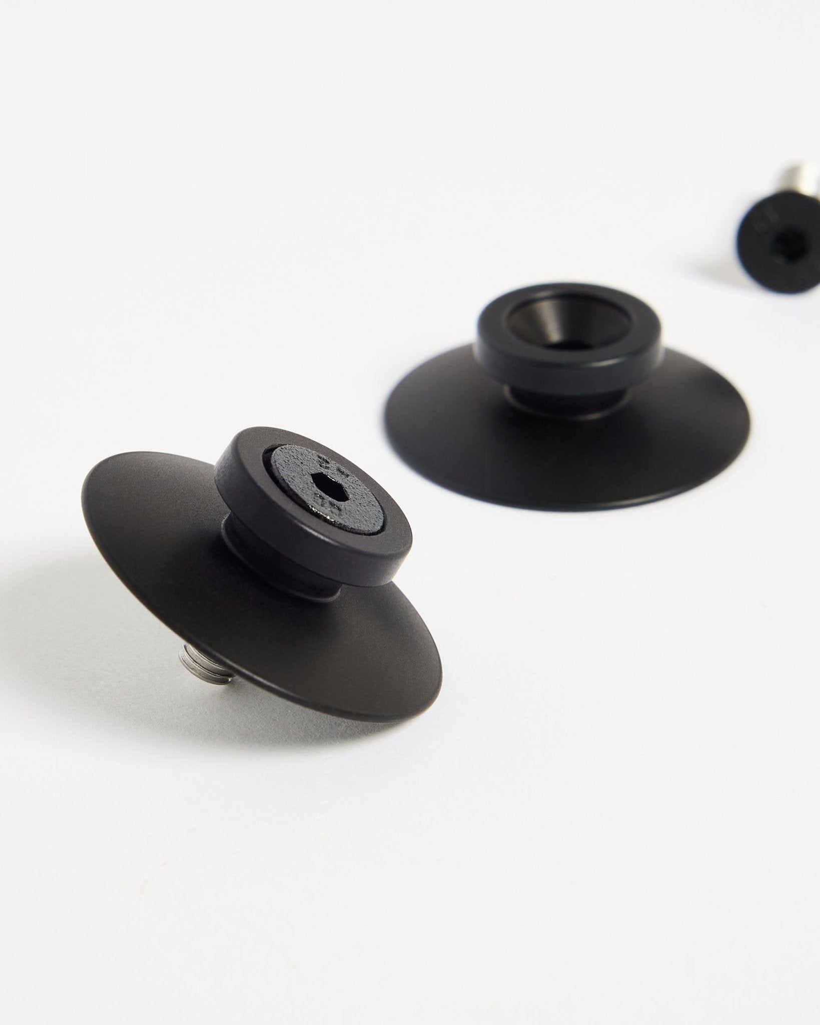 Twee black aluminium WoodUpp Dupps bevestigingen (2 stuks) op een wit oppervlak, ontworpen om akoestische panelen of room dividers stevig te monteren.