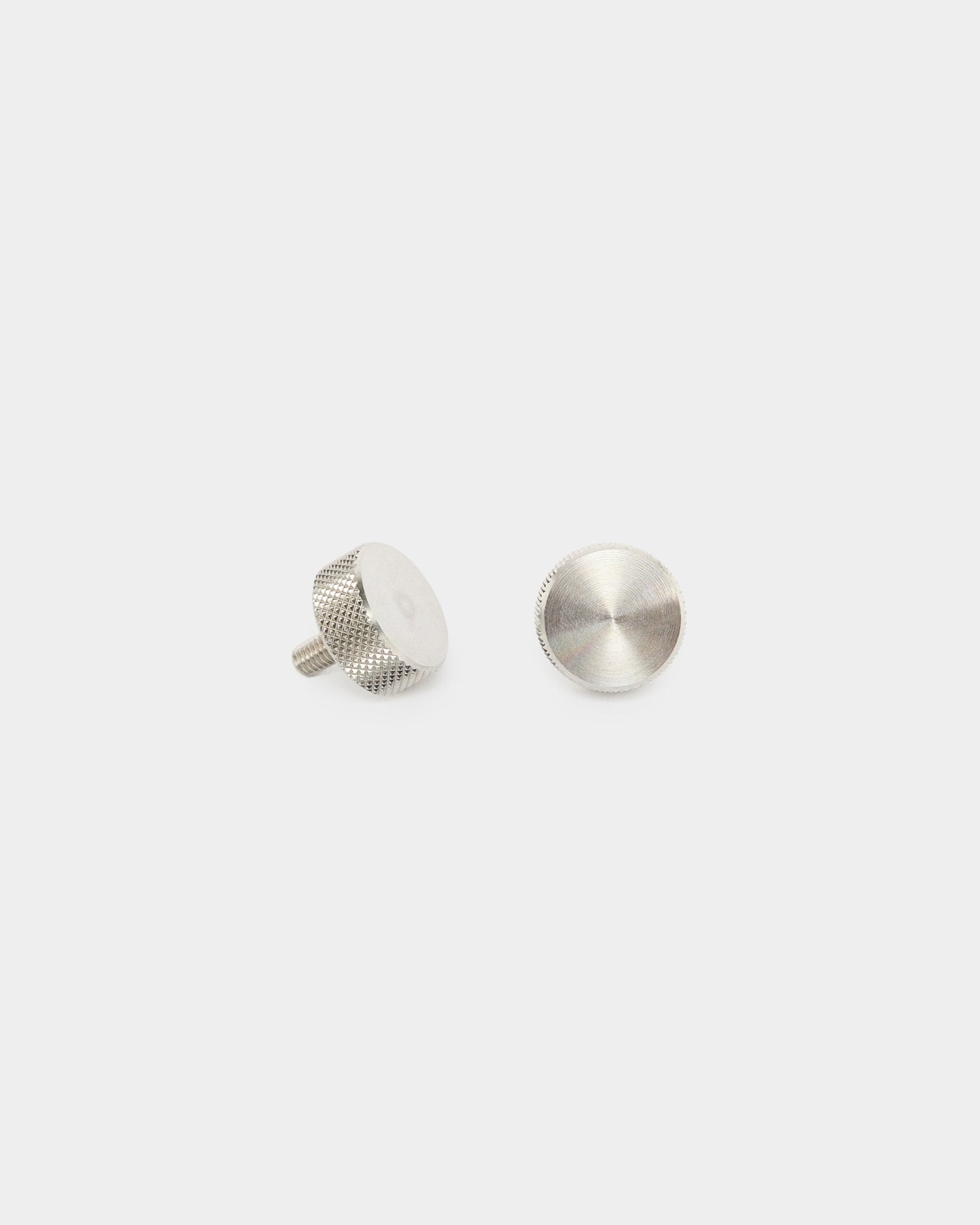 Twee WoodUpp roestvrijstalen steel vingerschroeven (M5x10mm, 20x8.8), accessoires voor Akupanel akoestische panelen, rechtop en plat weergegeven op een effen witte achtergrond.