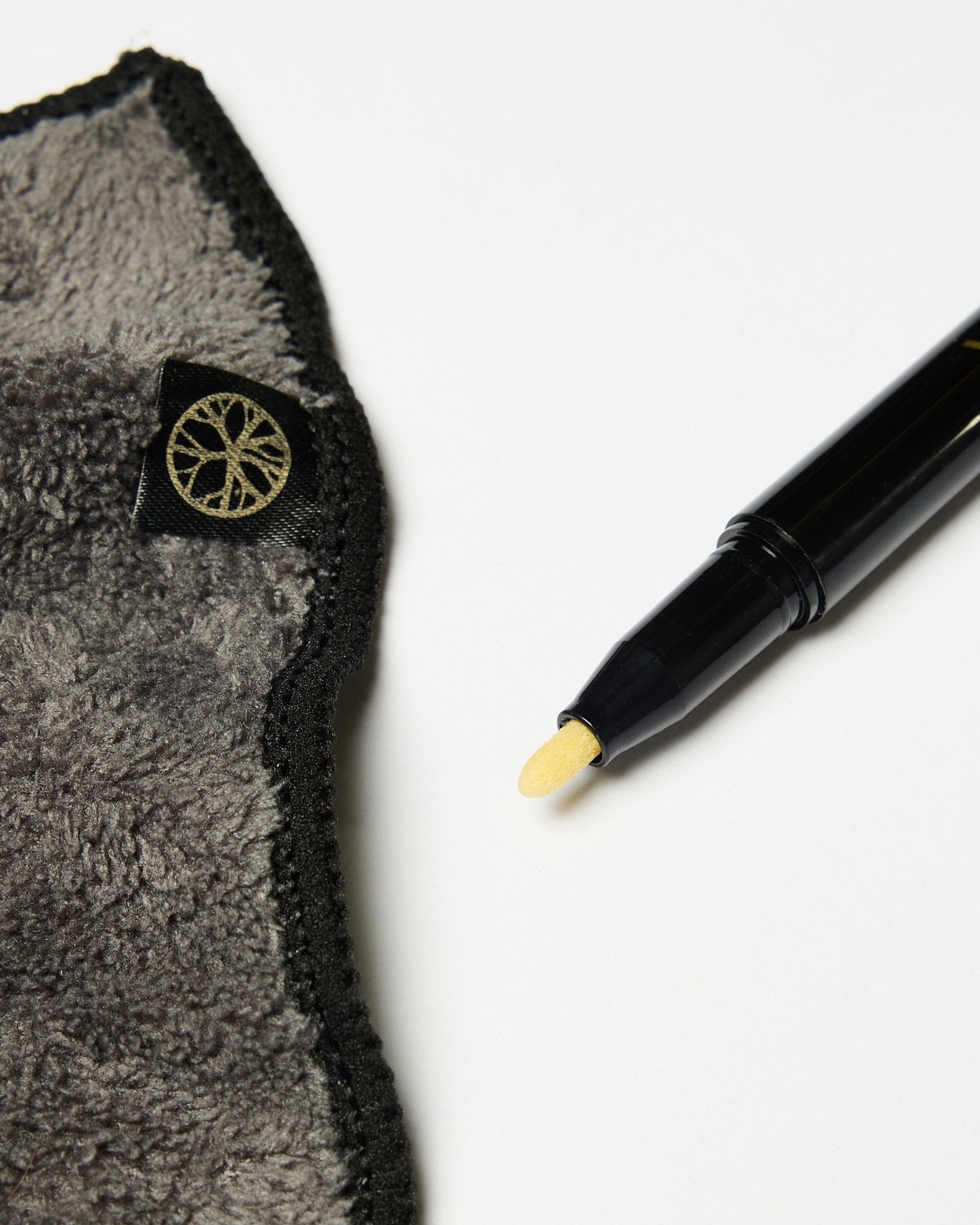 De Norr Blackboard-set van WoodUpp bevat een black krijtstift met gele punt en een grijze microvezeldoek met gouden label, weergegeven op een wit oppervlak.