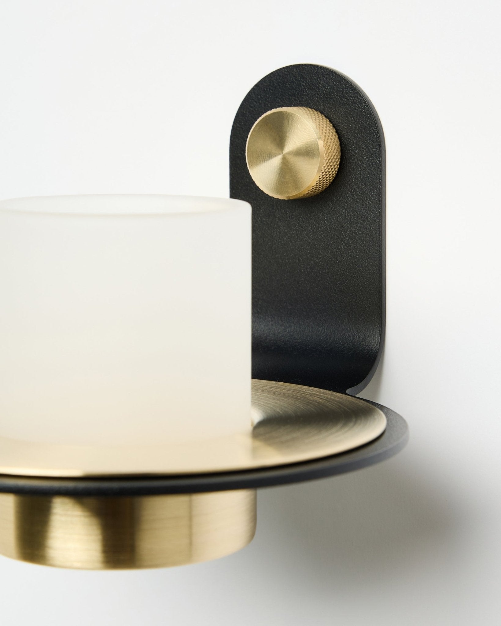 De Norr kaarsenhouder van WoodUpp, in black en brass, afgebeeld gemonteerd met LED-kaarsen op een witte Akoestisch paneel.