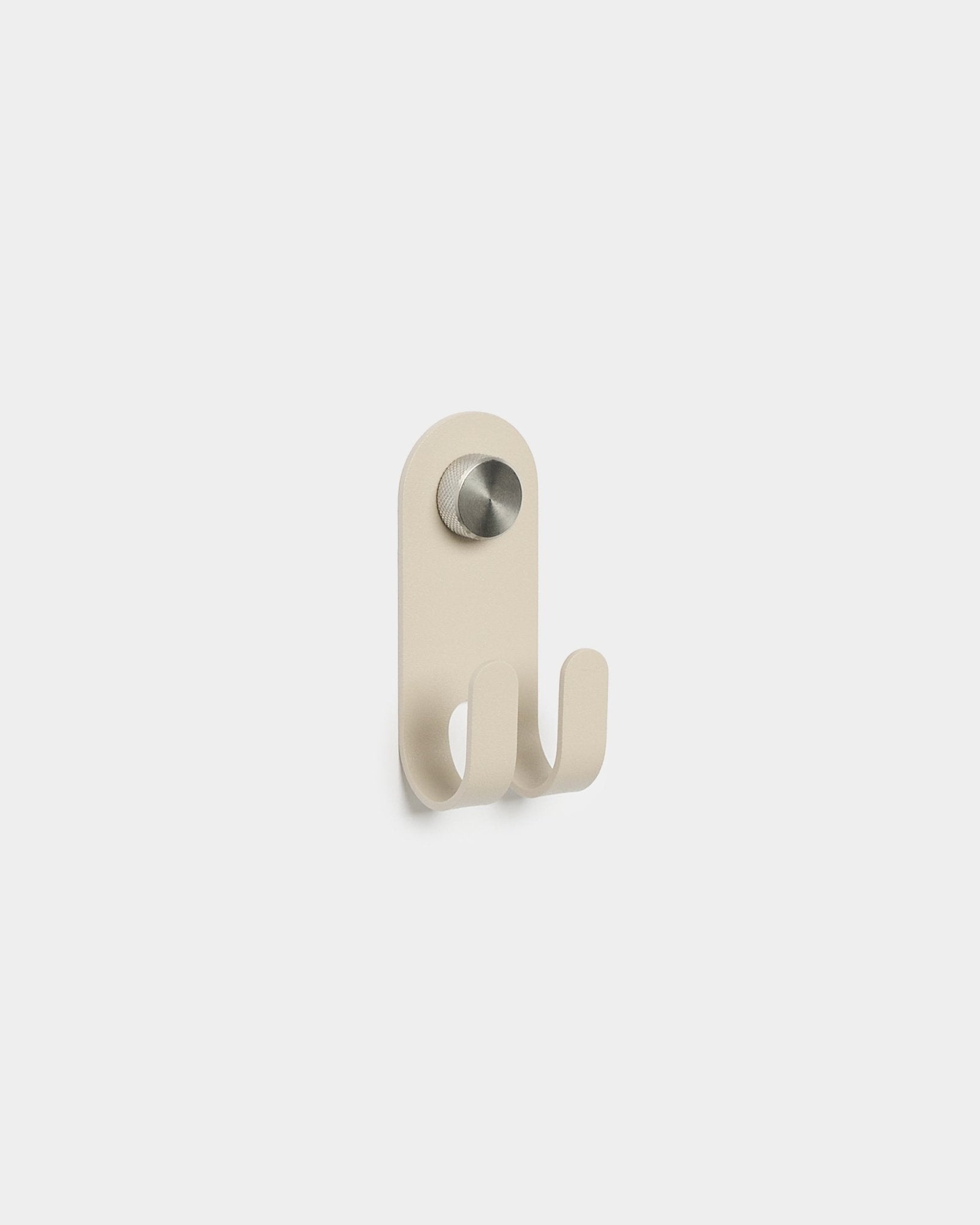 WoodUpp Norr Double Hanger in beige met twee metalen haken en een ronde zilveren knop, in een minimalistisch Scandinavisch design, getoond op een effen witte achtergrond.