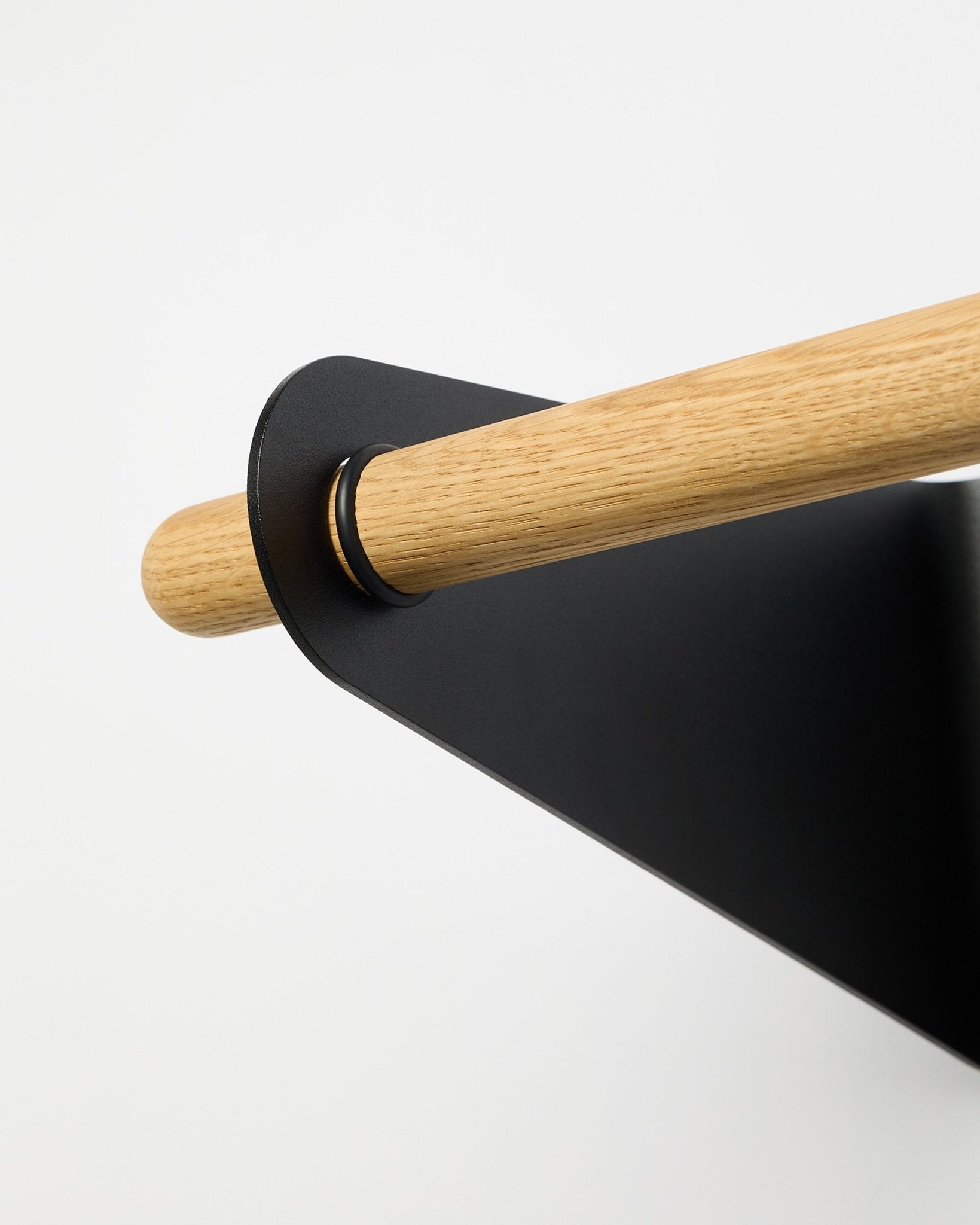 Close-up van de WoodUpp Linn Coat Rail in black (75,9 cm), gemonteerd in een black metalen beugel, getoond tegen een effen witte achtergrond.
