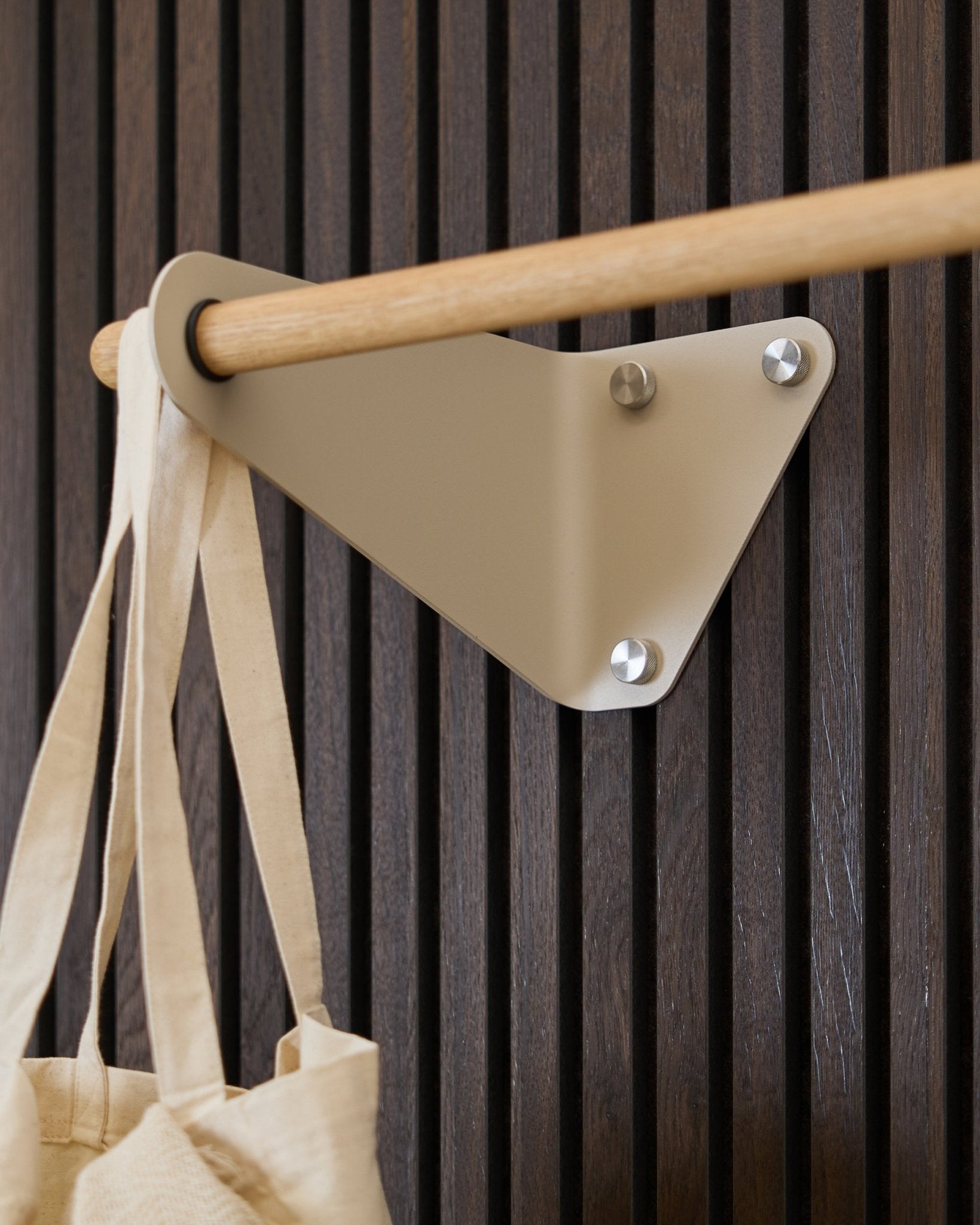 Beige WoodUpp Linn kapstok (115,9 cm), gemonteerd op Akupanel Akoestisch paneel, met links een crèmekleurige stoffen tas eraan.
