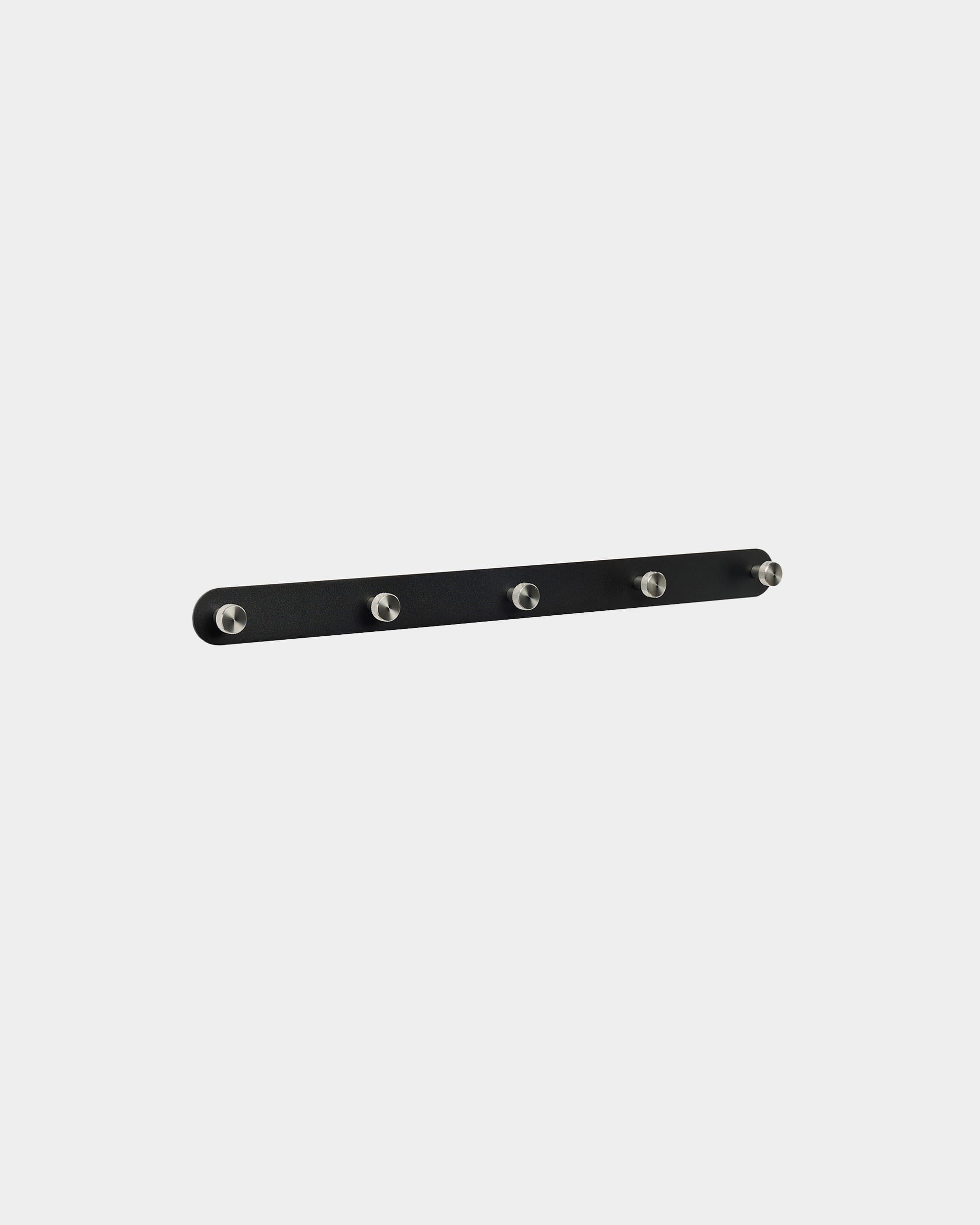 WoodUpp Norr kapstok met 5 haken in black en roestvrij steel, met vijf gelijkmatig verdeelde haken, gemonteerd tegen een effen witte achtergrond. Minimalistisch Nordisch design.