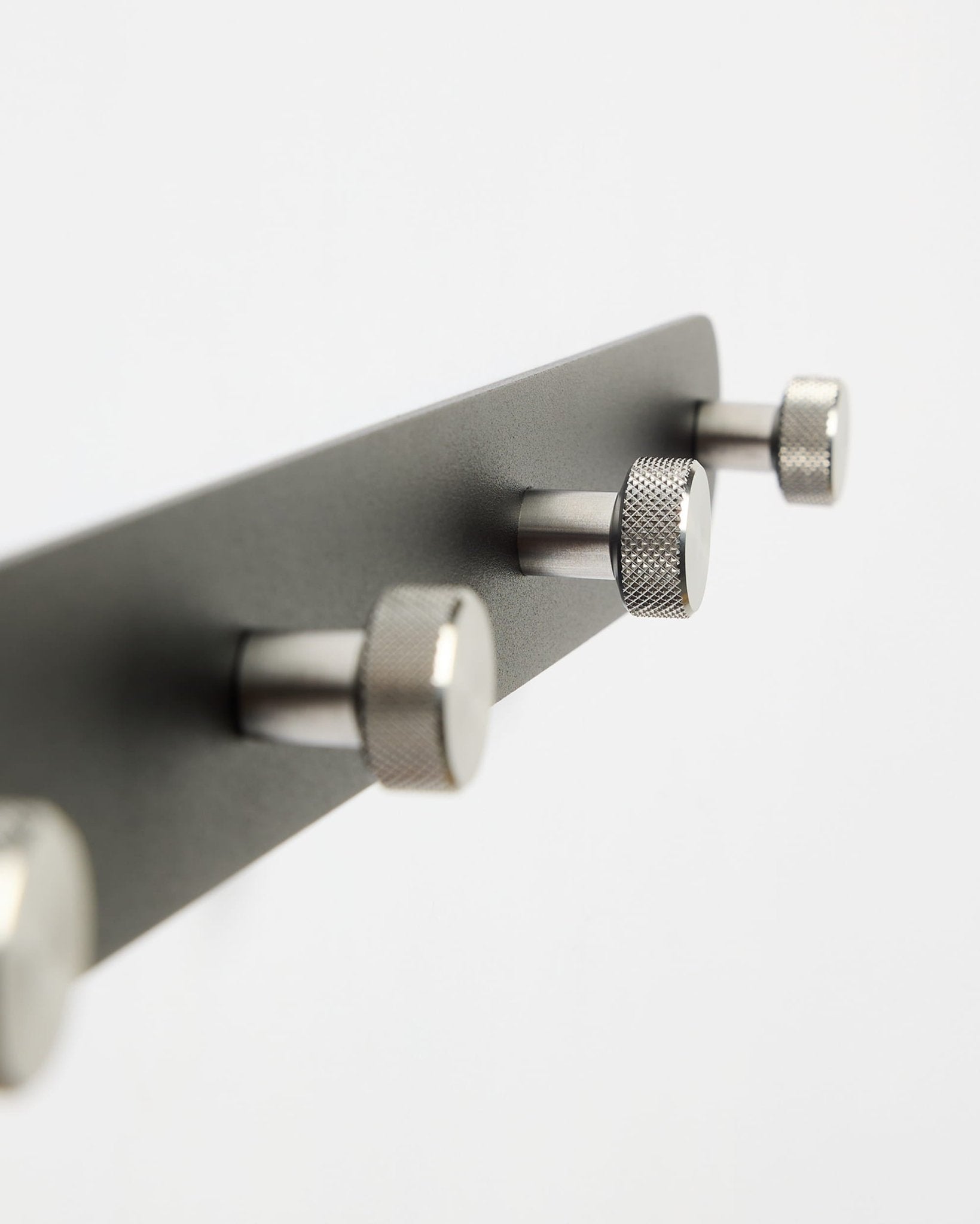 WoodUpp Norr Kapstok X7 in zwart en roestvrij staal met zeven haken, getoond tegen een strakke witte achtergrond; onderdeel van de CREATE-accessoirecollectie.