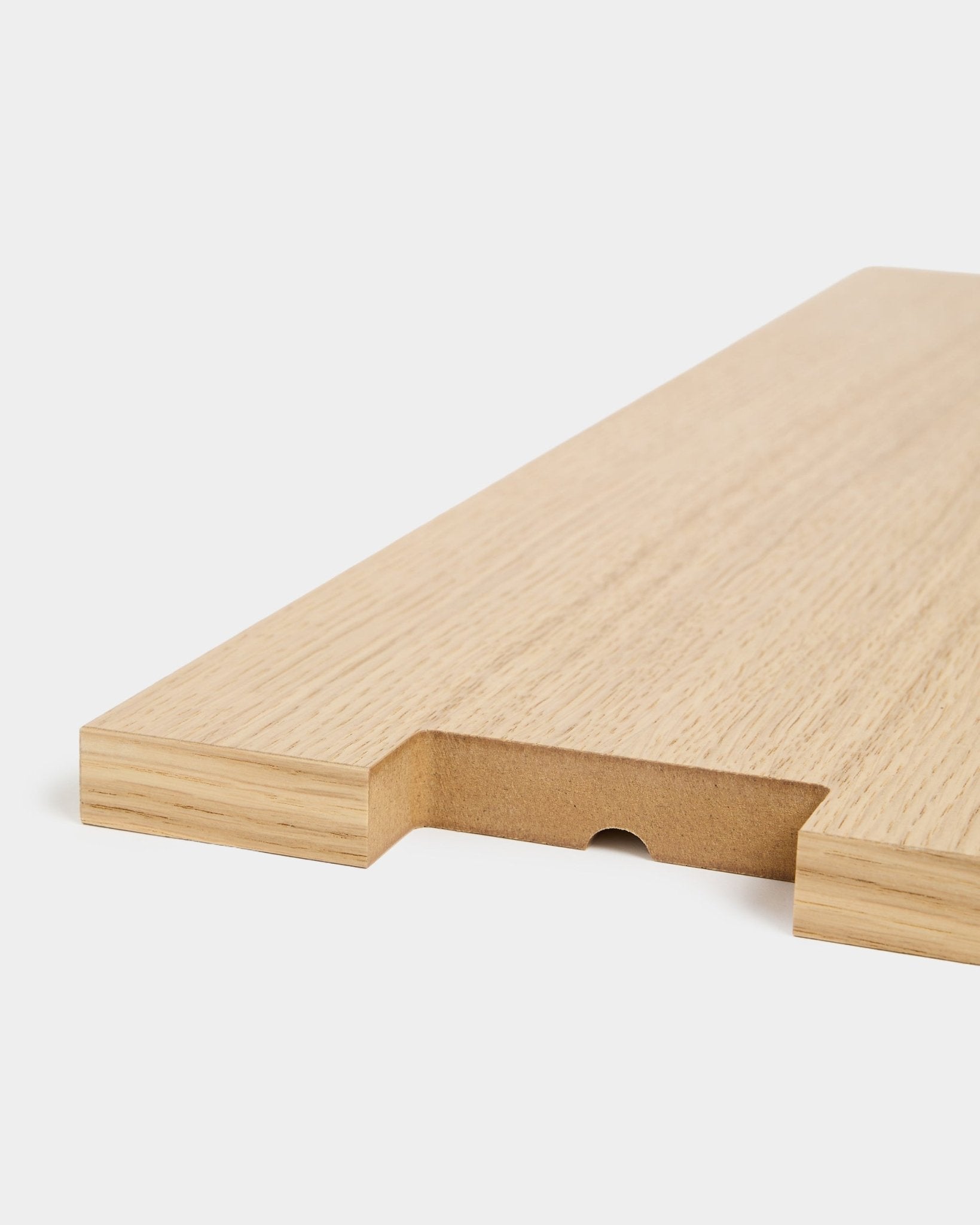Lova | Houten plank BM2 in eikenfineer van WoodUpp, 65,8 x 20 cm, van dichtbij getoond met een ingekeepte uitsparing en halfronde groef op een witte achtergrond.