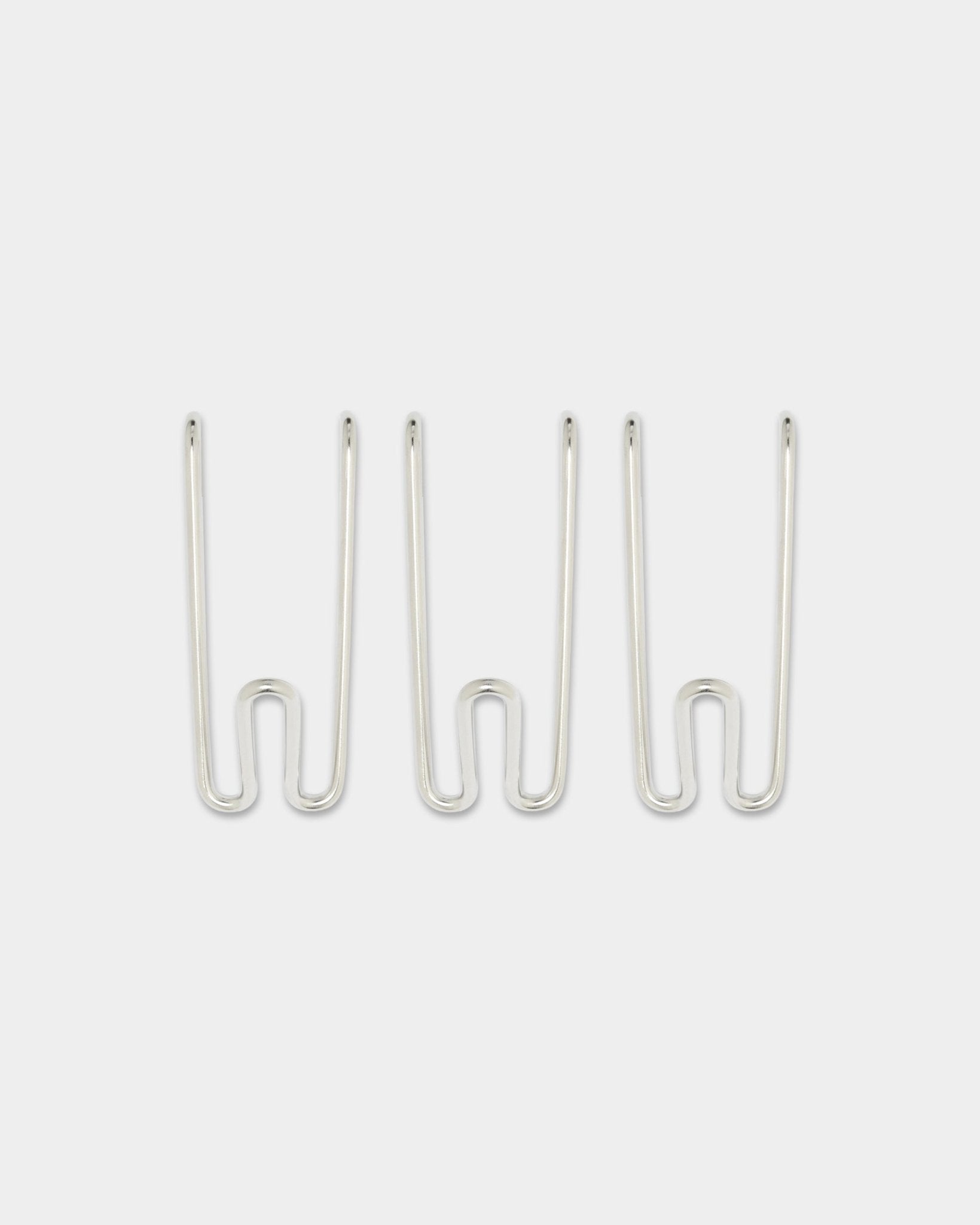 Drie Alva Wire Hooks BM1, kort, in roestvrij staal steel uit WoodUpp’s CREATE-collectie, gelijkmatig verdeeld tegen een effen witte achtergrond.