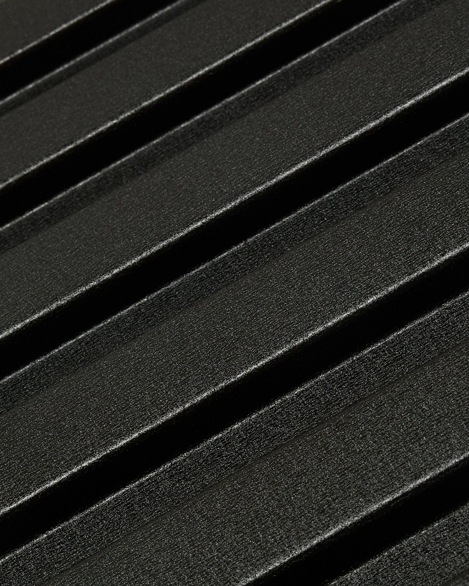 Close-up van het Aluwood gevelpaneel voor buiten van WoodUpp: donker oppervlak van gerecycled aluminium met textuur en diagonale verhoogde ribbels, 240 x 45,1 cm.