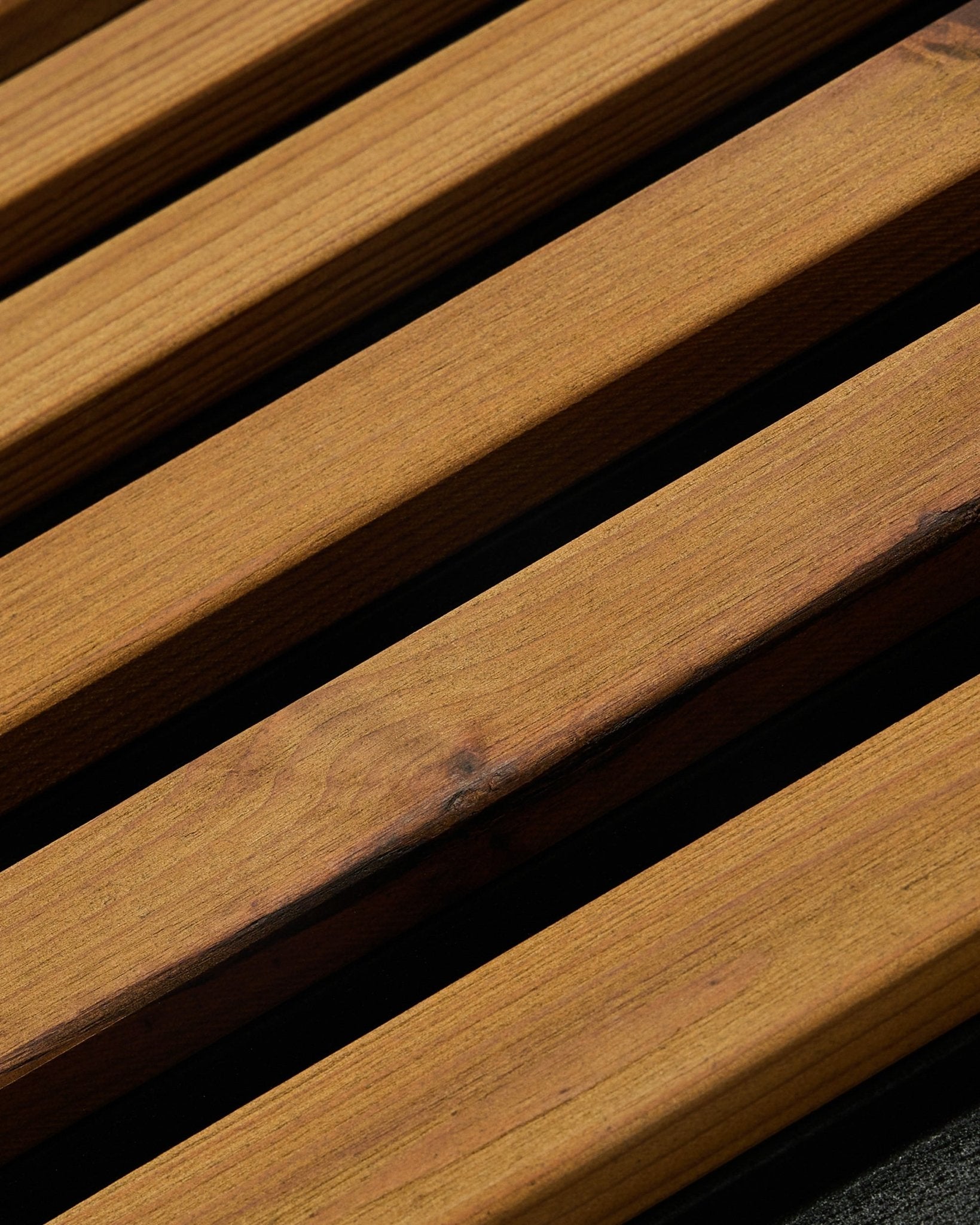 Close-up van WoodUpp Aluwood gevelpaneel in geolied brown (240 x 45,1 cm), van thermisch behandeld Scandinavisch sparrenhout, schuin gefotografeerd om de latten met donkere tussenruimtes te tonen.