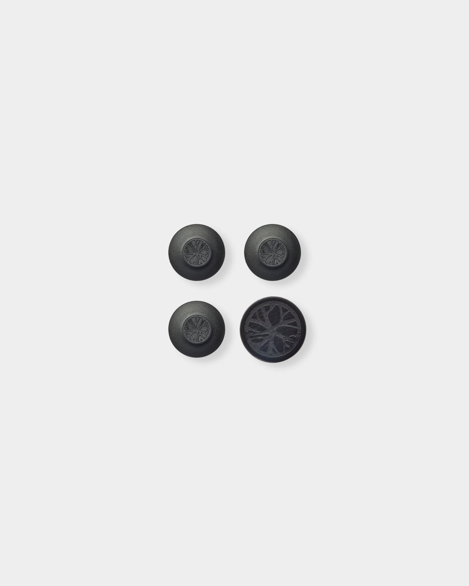 Drie ronde black Dupps en één rond onderdeel met een gedetailleerd akoestisch houtlatpatroon, geïnspireerd op Nordic WoodUpp Akupanel, op een lichtgrijze achtergrond.