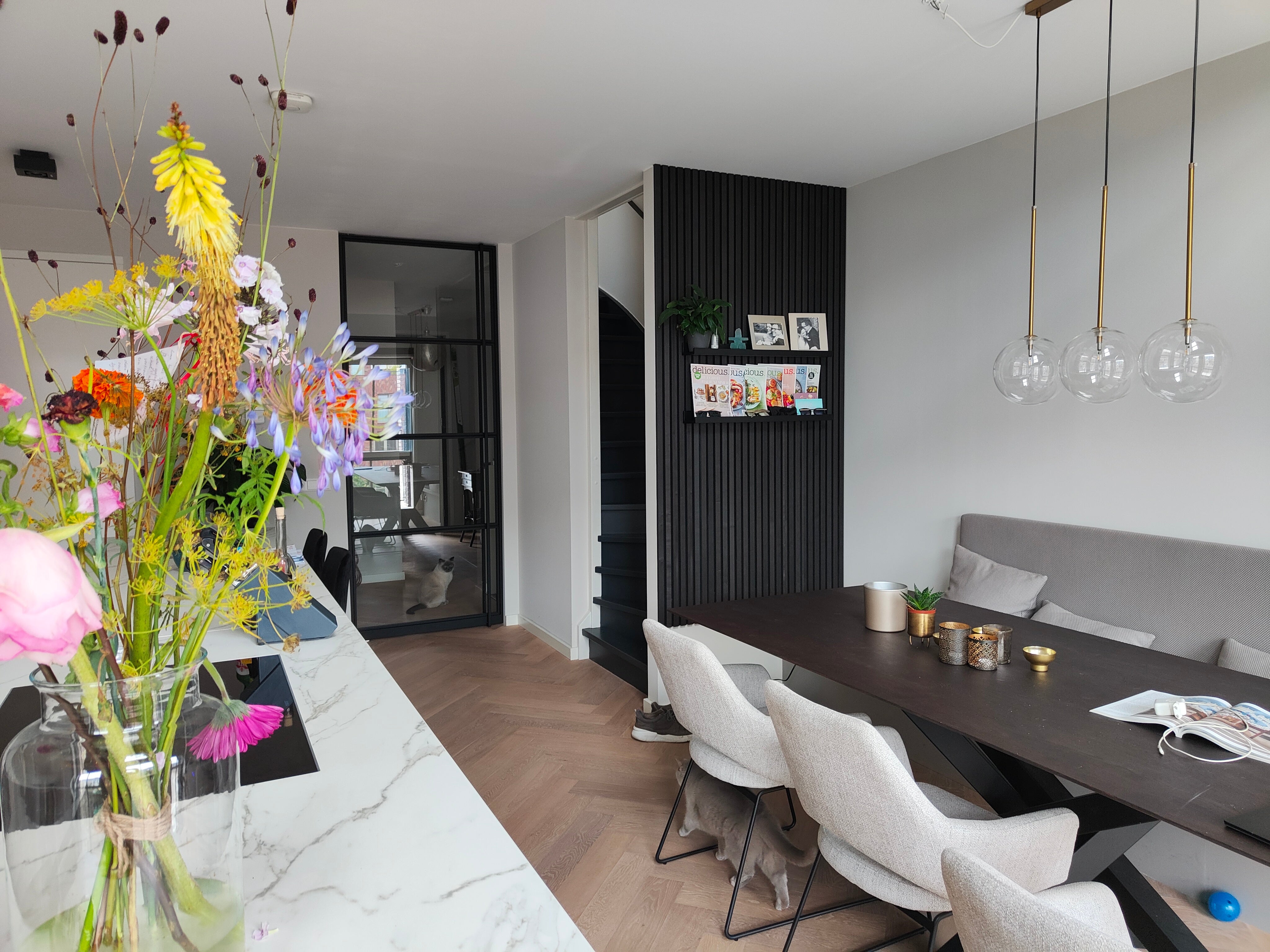 Black Akupanel acoustic slat wall panel with shelf and framed photos in an interior dining area