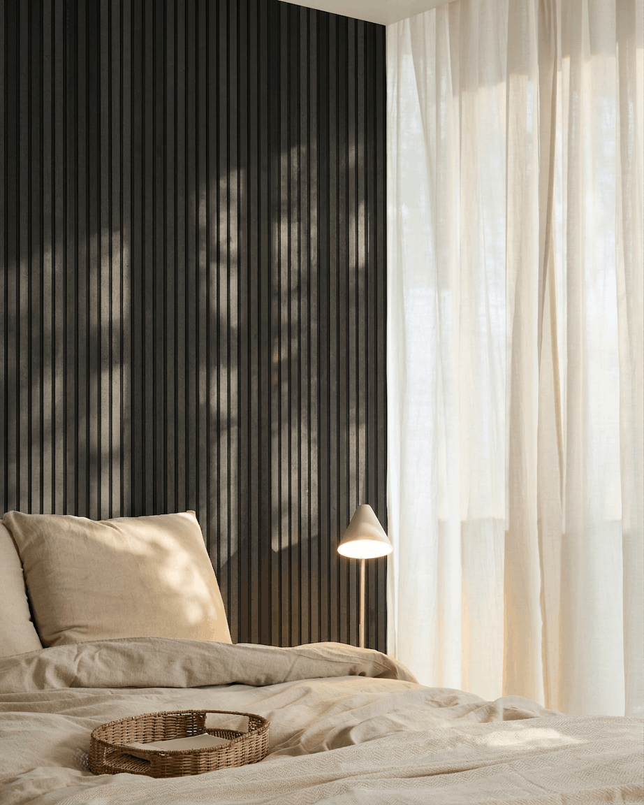Minimalistische Scandinavische slaapkamer met een WoodUpp Akupanel Akoestisch paneel in Black Ash, beige beddengoed, een rieten dienblad en transparante gordijnen die natuurlijk licht doorlaten.