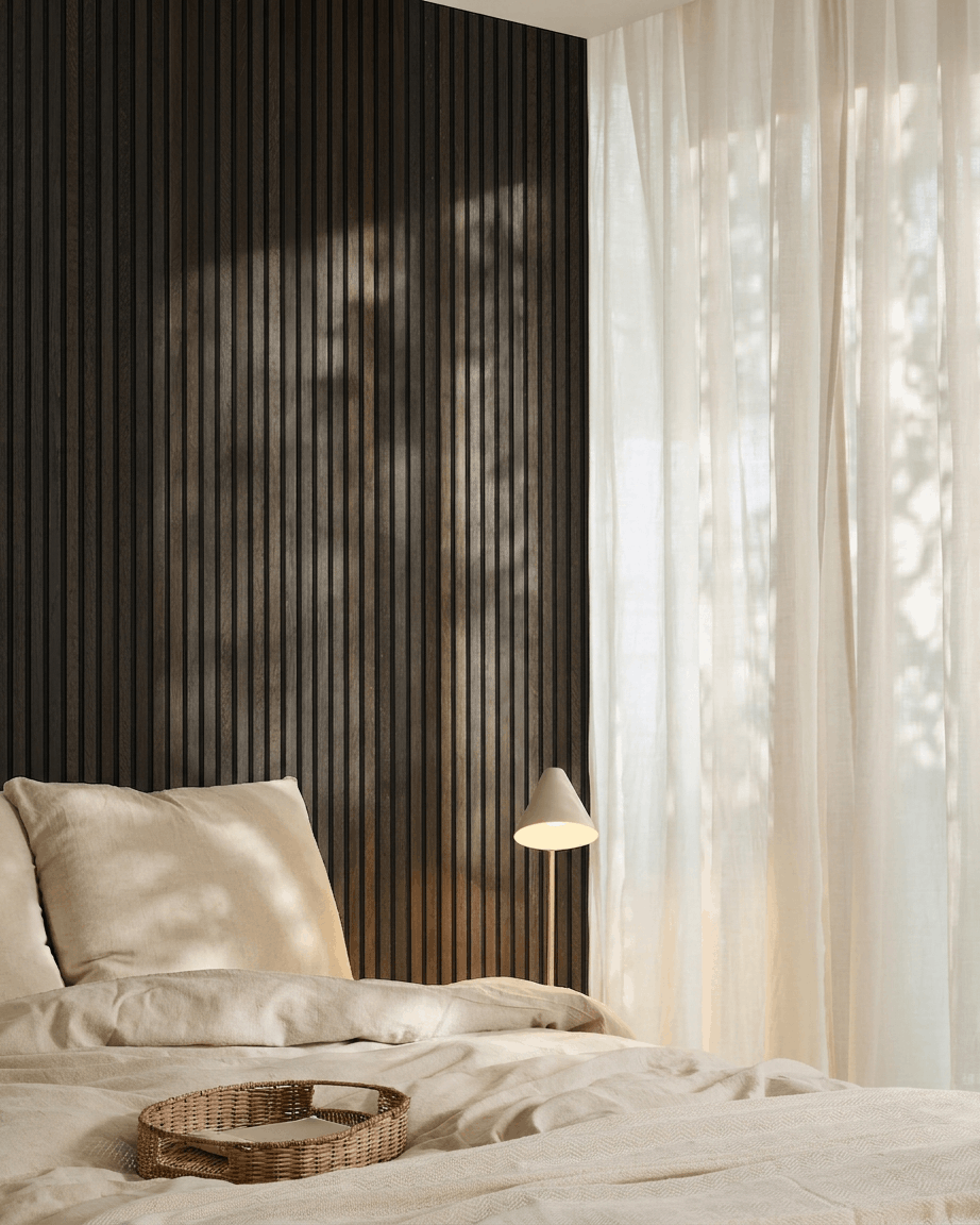 Minimalistische slaapkamer met een beige bed, rieten dienblad, Scandi-accenten en een WoodUpp Akupanel akoestisch houten paneel in Rustic Smoked Oak, gemonteerd op een donkere muur.