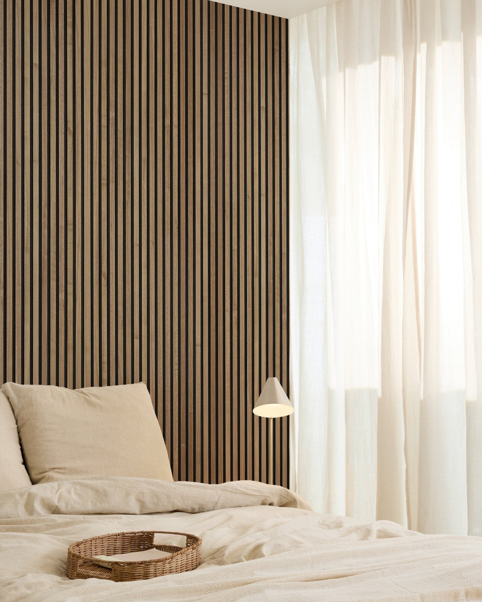 Minimalistische slaapkamer met een WoodUpp Original Akupanel Walnut Akoestisch paneel (240x60cm) aan de wand, beige beddengoed, transparante gordijnen, een geweven dienblad en een small wandlamp.
