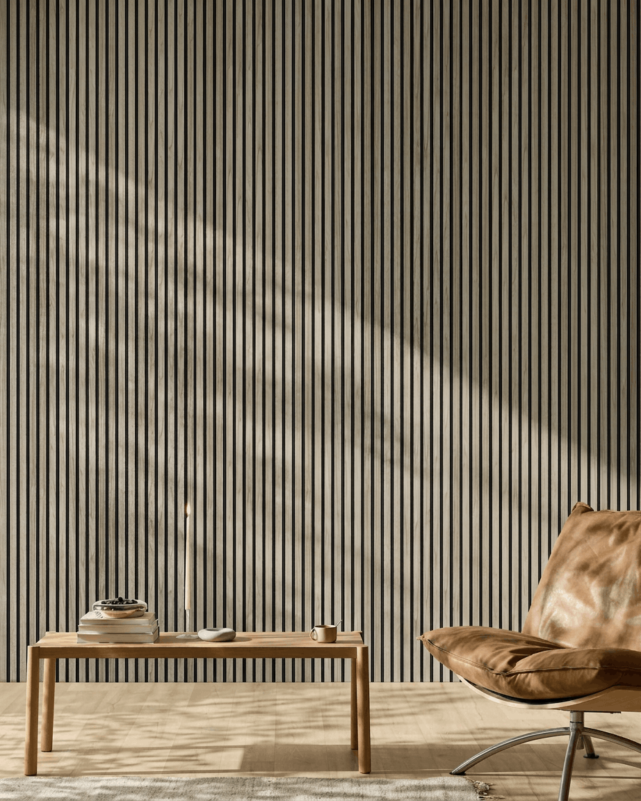 Minimalistische ruimte met een 240x60 cm WoodUpp Akupanel in Weathered Oak met black vilt, een houten bank, boeken, een kaars, een kopje en een lichtbruine leren stoel.