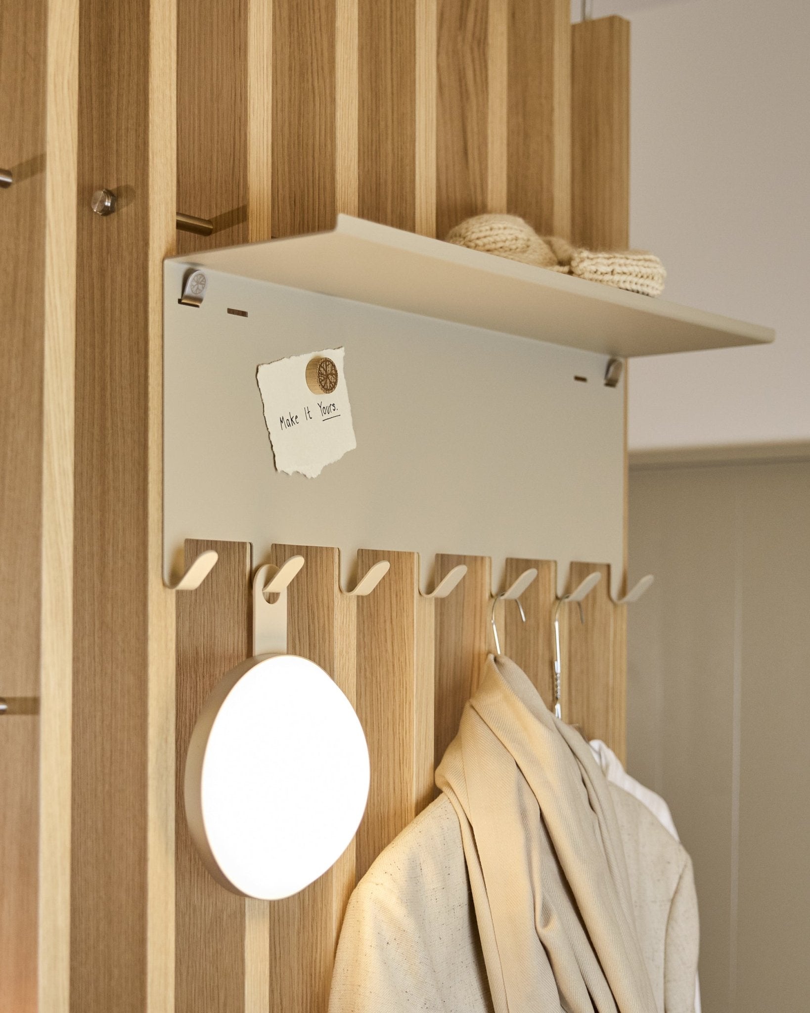 WoodUpp Nell | BM1 kapstok in beige (63,5 x 24 cm), met steel haken en een plank met breiwerk en een briefje met de tekst embrace BM1.