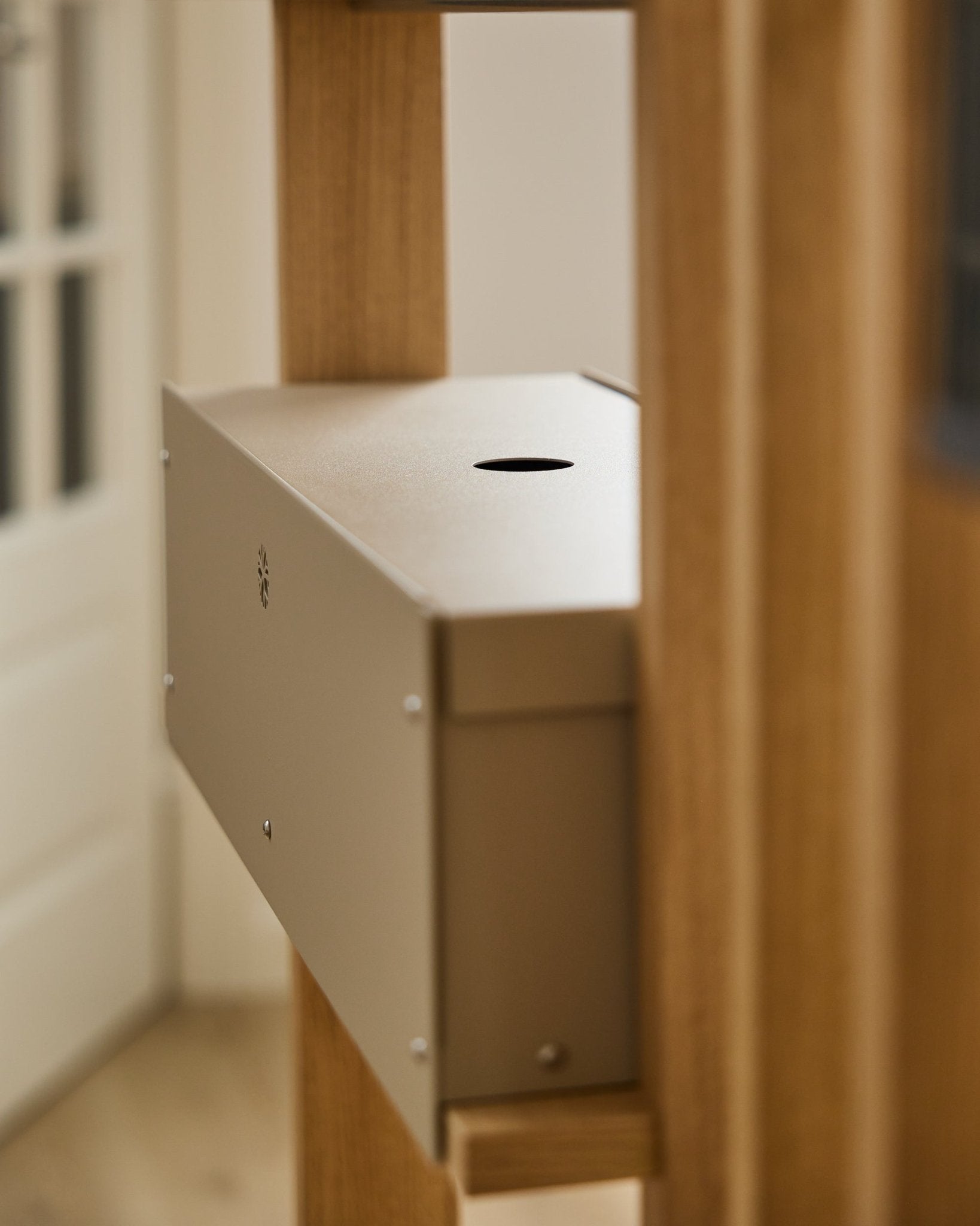 De Nell | Metal Box / BM2, Beige van WoodUpp is een accessoire van steel met poedercoating uit de CREATE-collectie, geplaatst tussen akoestische houten panelen naast een witte deur.